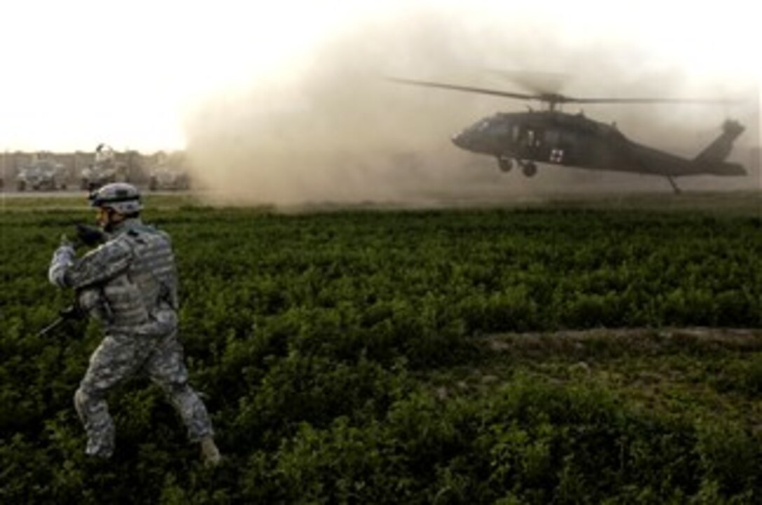 U.S. Army 1st Sgt. Wray Gablemann, of 187th Infantry Regiment, 3rd Brigade Combat Team, 101st Airborne Division, runs to guide a U.S. Army UH-60 Blackhawk medical evacuation helicopter to the landing zone as it arrives in Owesat, Iraq, Dec.18, 2007, to evacuate injured Iraqi personnel who were attacked at a Concerned Local Citizen checkpoint by a suicide bomber. 