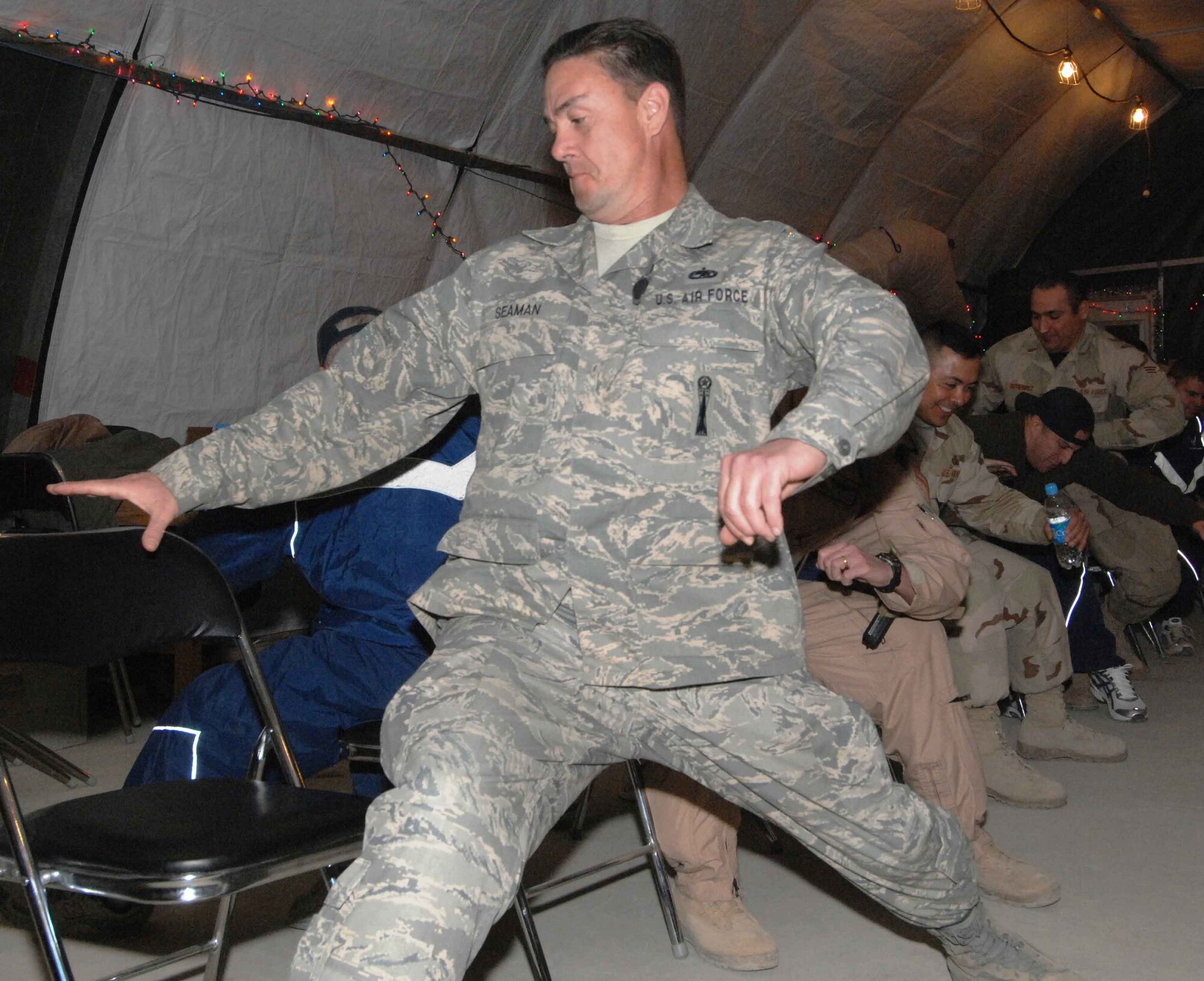 BAGRAM AIR BASE, Afghanistan - Master Sgt. Mark Seaman, 455th Air Expeditionary Wing safety office, races for a seat as part of  a “musical chairs” games during a holiday celebration co-sponsored by the 455th Expeditionary Mission Support Squadron, private organizations and volunteers, Dec. 23.  (U.S. Air Force Photo by Capt. Mike Meridith)