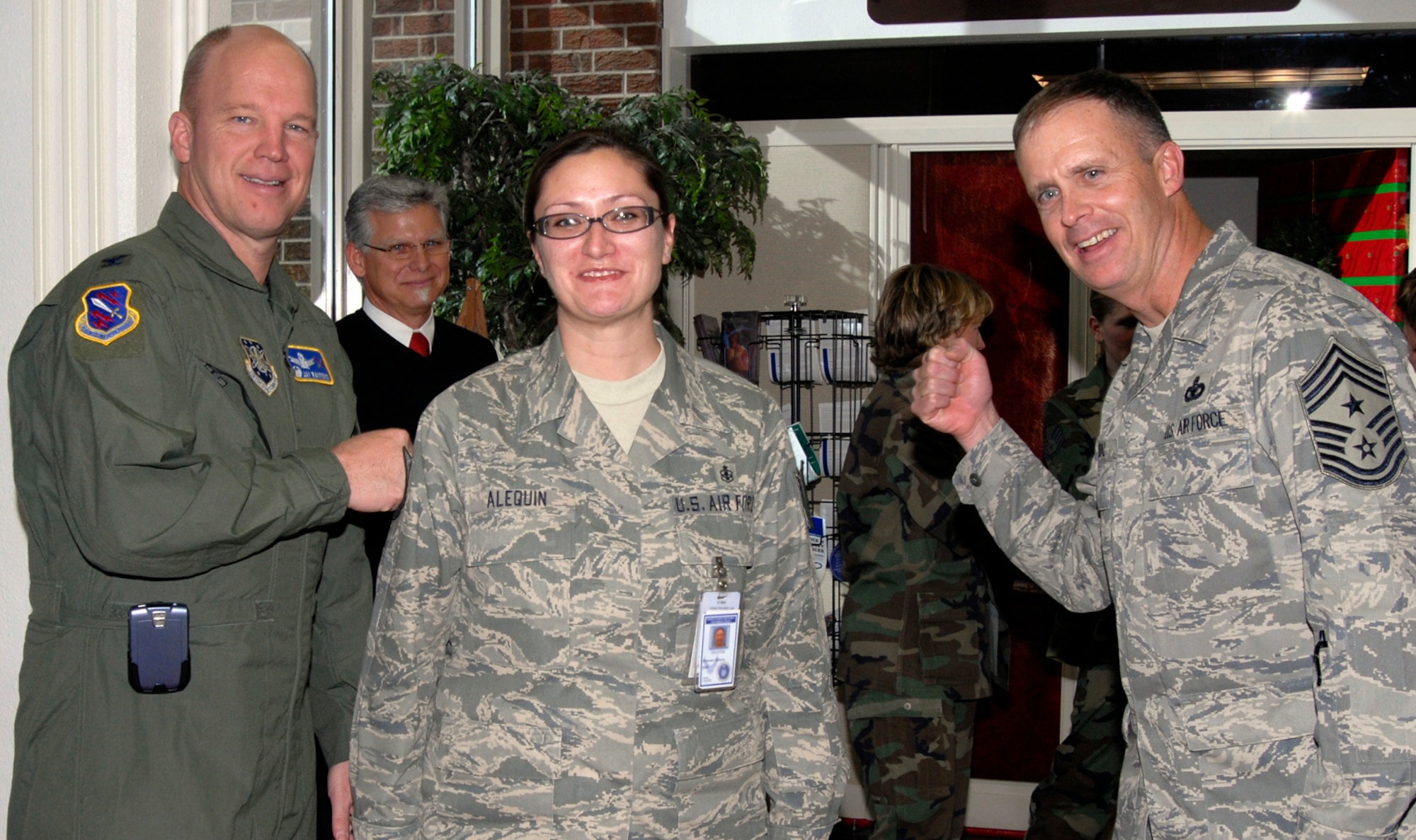 Newly-promoted Tech. Sgt. Shannon Alequin gets her new stripe ‘tacked’ on by 21st Space Wing commander Col. Jay Raymond and Chief Master Sgt. Timothy Omdal, 21st SW command chief, after being ‘STEP’ promoted Dec. 21. Known as ‘Stripes for Exceptional Performers,’ units use additional promotion slots to promote exceptional members in their organizations. Sergeant Alequin is assigned to the 21st Medical Support Squadron. (U.S. Air Force photo/Roberta McDonald)