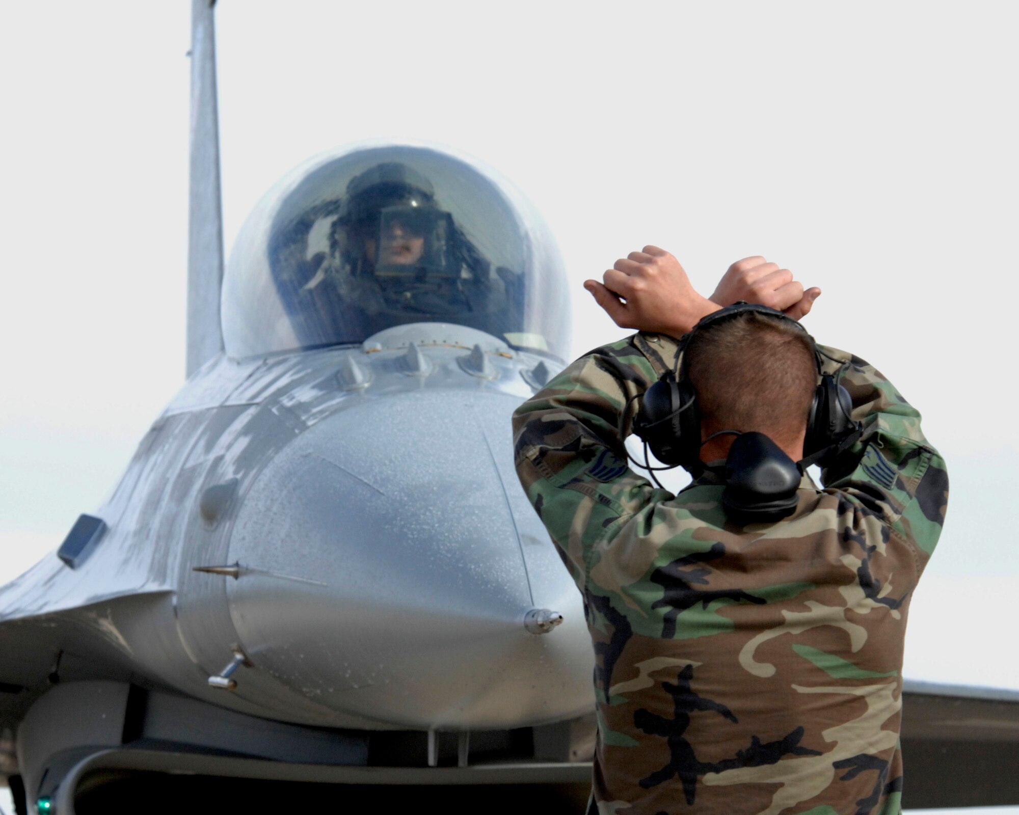 CANNON AIR FORCE BASE, N.M. -- Staff Sgt. Vann Pennington, 522nd Fighter Squadron crew chief, guides in Maj. Bob Battema, 522FS director of operations, after the squadron's final flight. After the flight, the 522FS inactivated and was the final F-16 fighter squadron to do so at Cannon after a decision from the Base Realignment and Closure Commision forced the base to find a new mission. As a result, Air Force Special Operations Command took control of Cannon and their first squadron, the 73rd Special Operations Squadron, is in place now. (U.S. Air Force photo/Airman 1st Class Erik Cardenas)