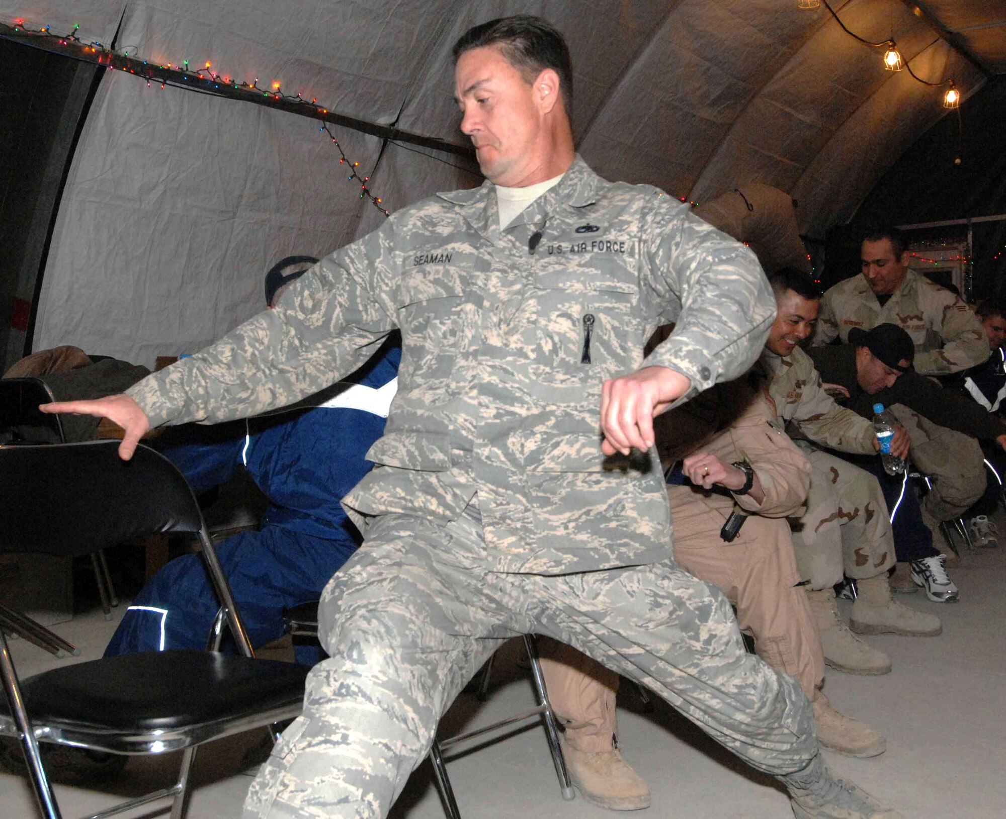 Master Sgt. Mark Seaman races for a seat as part of a "musical chairs" games during a holiday celebration co-sponsored by the 455th Expeditionary Mission Support Squadron, private organizations and volunteers Dec. 23 at Bagram Air Base, Afghanistan. Sergeant Seaman is assigned to the 455th Air Expeditionary Wing Safety Office. (U.S. Air Force photo/Capt. Mike Meridith)