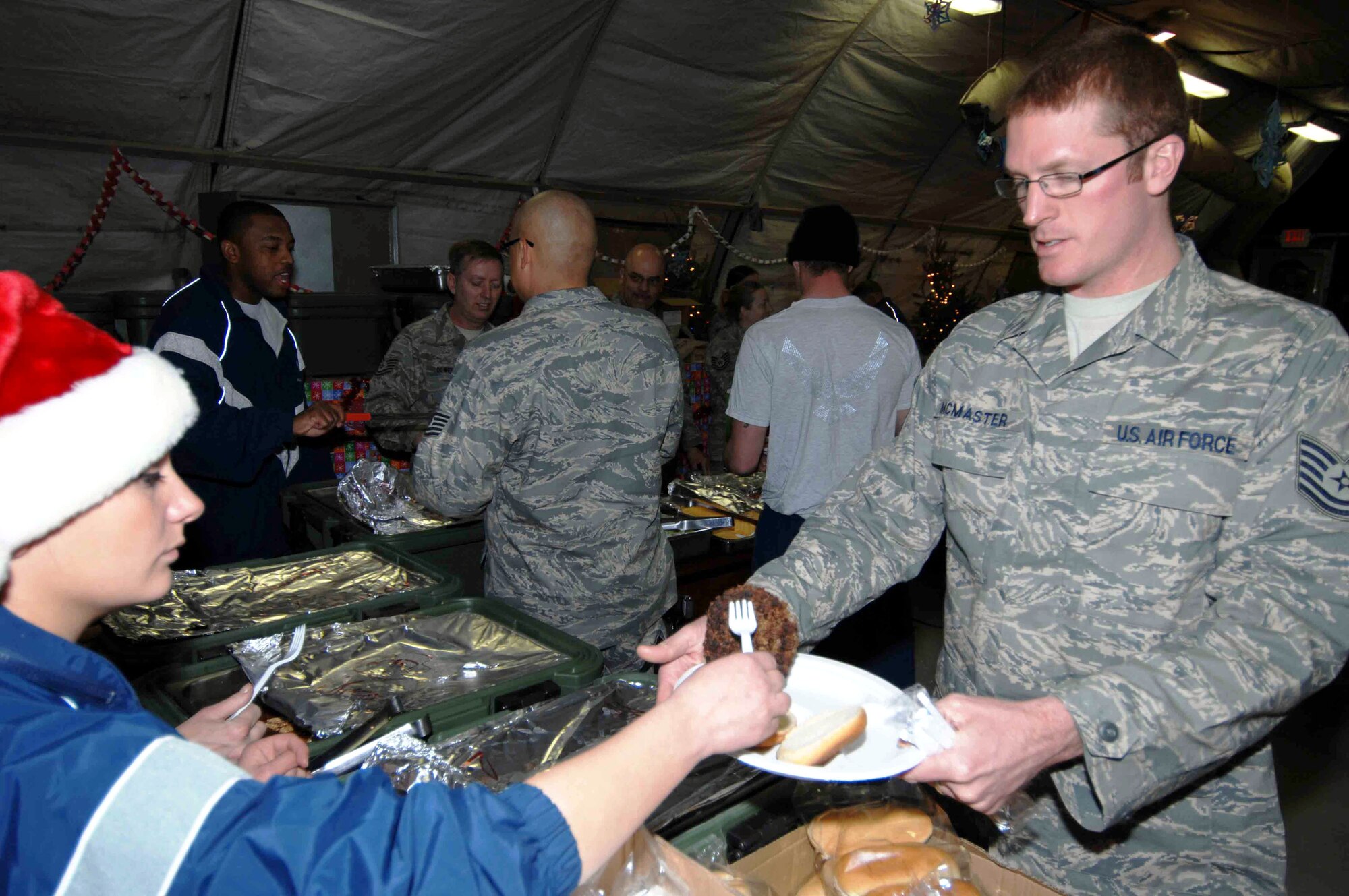 Tech. Sgt. Ryan McMaster is served a holiday meal during a celebration co-sponsored by the 455th Expeditionary Mission Support Squadron, private organizations and volunteers Dec. 23 at Bagram Air Base, Afghanistan. Sergeant McMaster is assigned to the 774th Expeditionary Airlift Squadron. (U.S. Air Force photo/Capt. Mike Meridith)