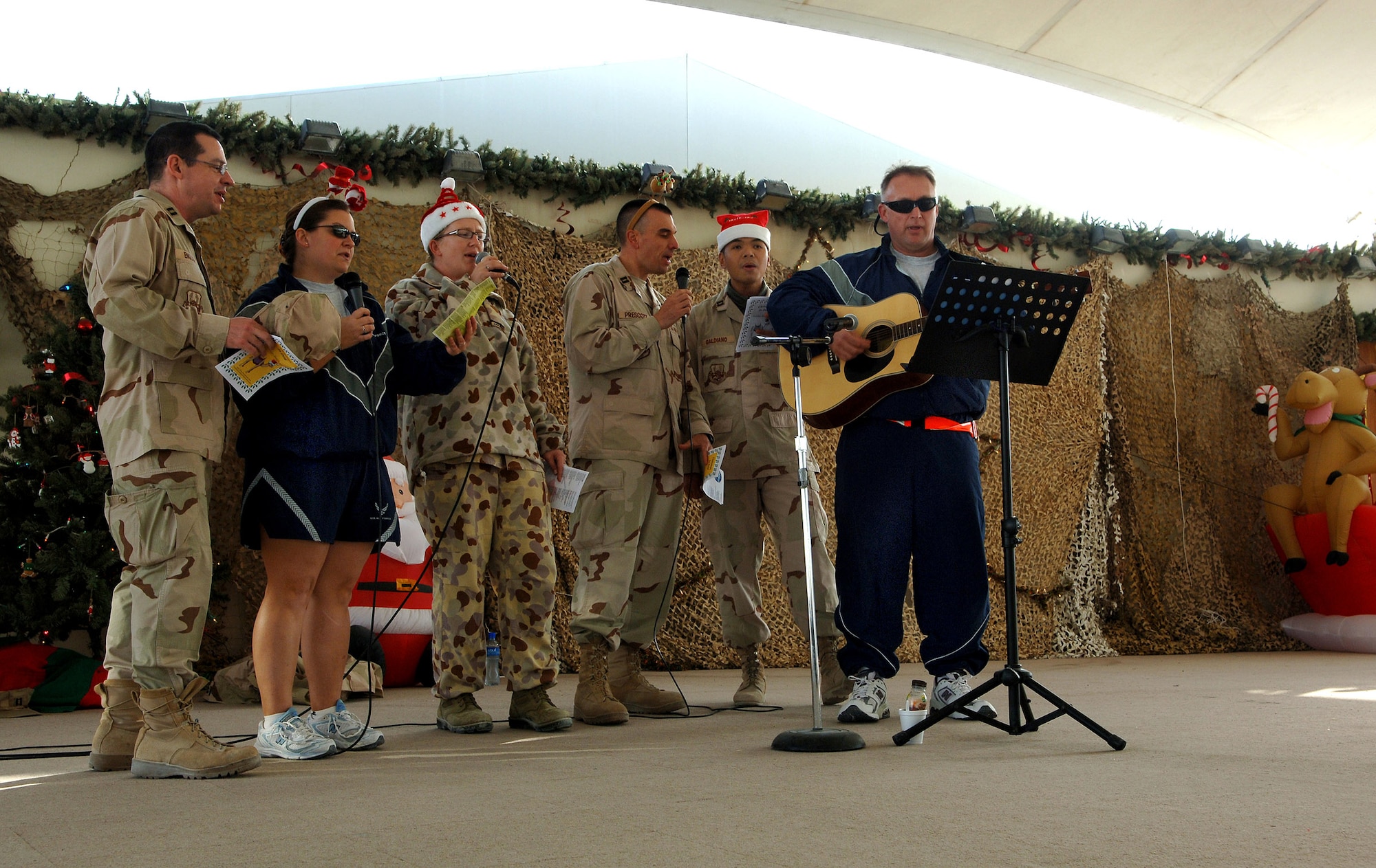 Chaplain (Capt.) Jason English (from left), Maj. Tracey Birri, Royal Air Force member Sarah Clark, Capt. Deric Prescott, Capt. Ray Galdiano and Senior Master Sgt. Dan DeMers sing classic holiday songs to a breakfast crowd at Memorial Plaza Dec. 25 at a Southwest Asia air base. (U.S. Air Force photo/Master Sgt. Greg Kunkle) 
