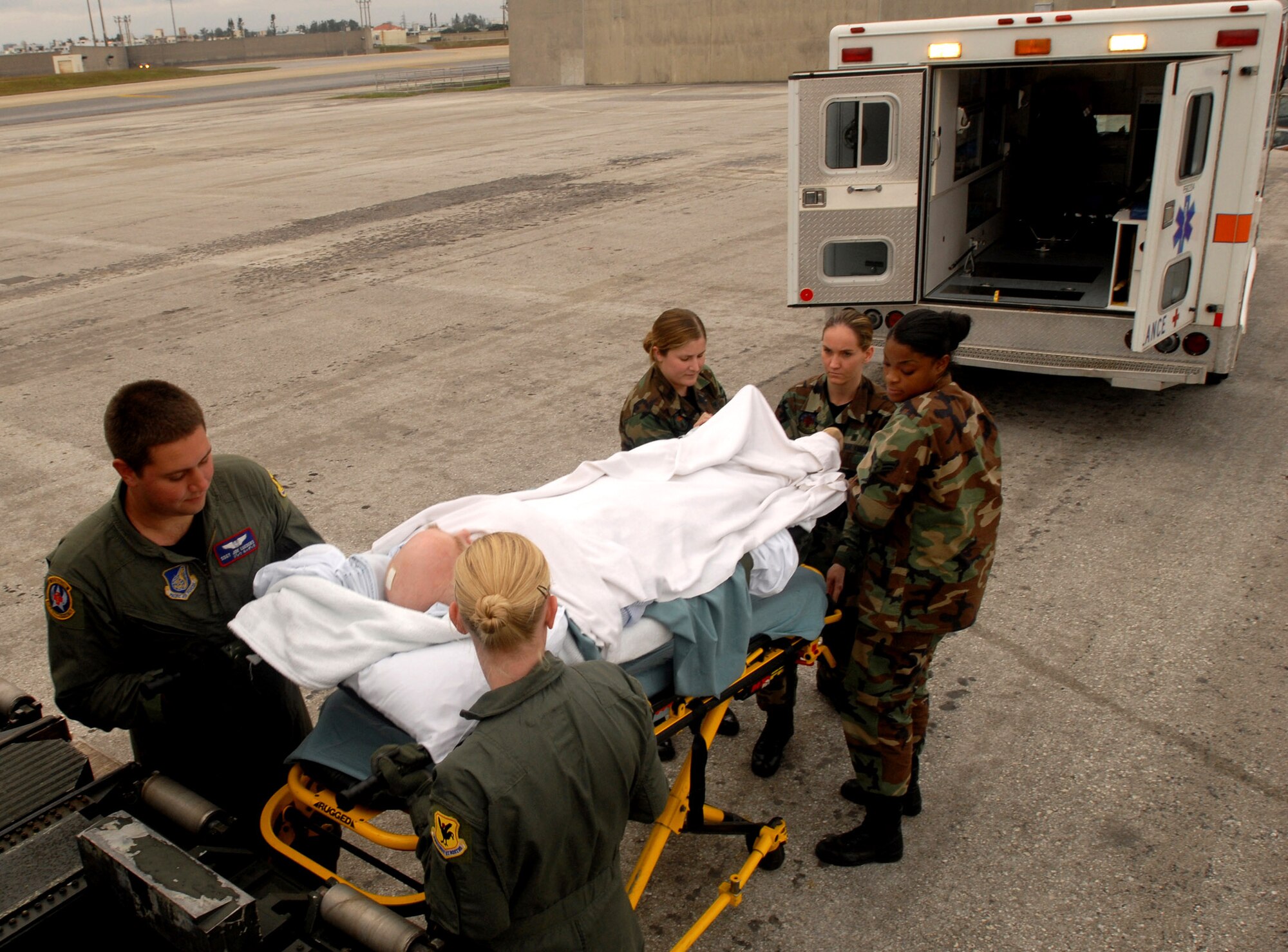 Airmen from the 18th Aeromedical Evacuation Squadron, the 18th Medical Operations Squadron and 18th Aerospace Medicine Squadron work together to carry a patient onto a KC-135 Stratotanker Dec. 18 at Yokota Air Base, Japan, bound for Kadena Air Base, Japan. The patient will stay at the Camp Lester Naval Hospital for the night to receive critical care before being transported to Travis Air Force Base, Calif., for further treatment. Members of the 18th AES travel throughout the Pacific picking up critical patients and transporting them to hospitals that can meet their needs. (U.S. Air Force photo/Staff Sgt. Chrissy FitzGerald) 
