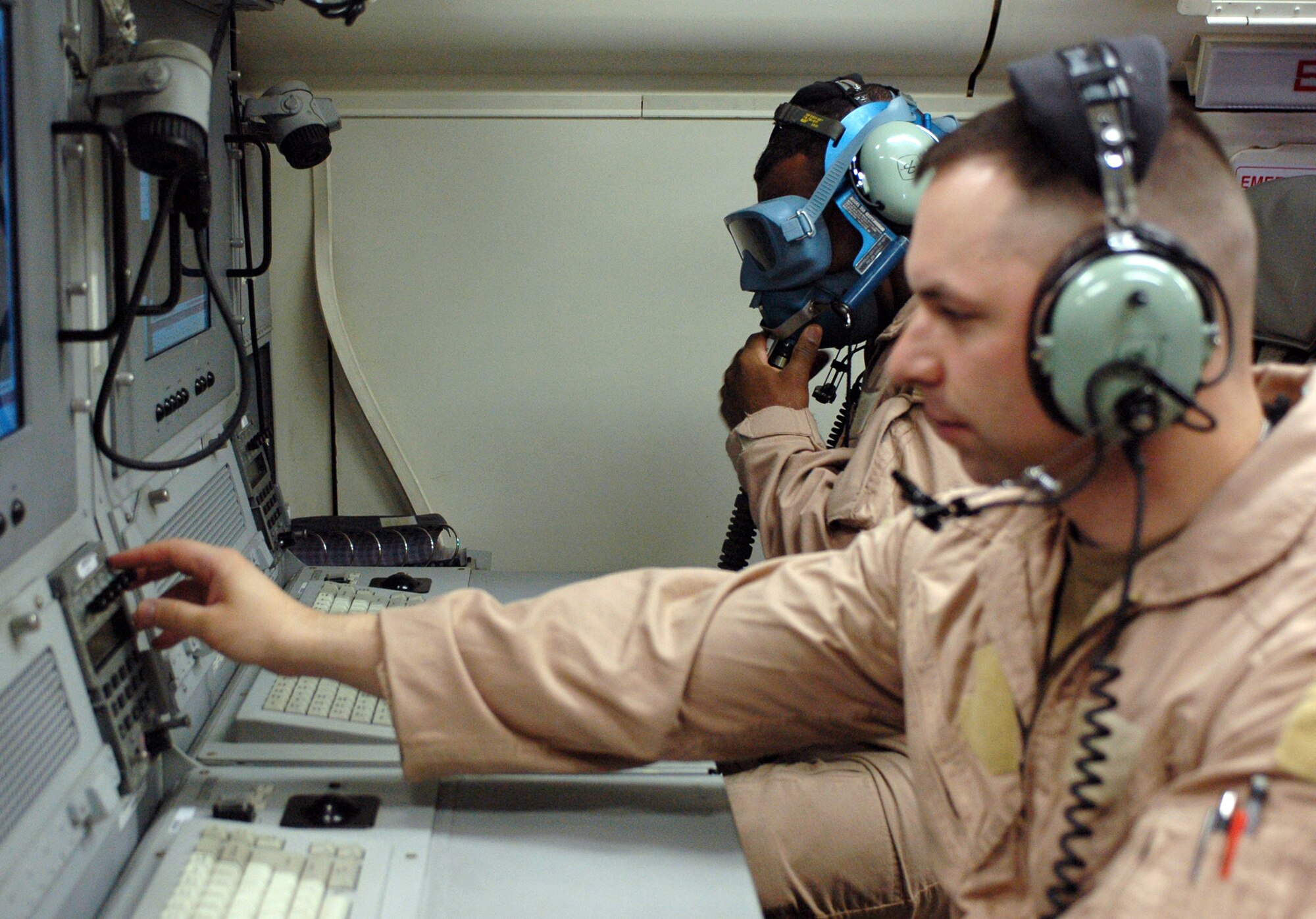 Army Maj. Darryl Verrett (rear) ensures his oxygen mask works properly while Capt. Stefan Essig begins a computer systems check aboard an E-8C Joint Surveillance Target Attack Radar System aircraft prior to takeoff from an air base in Southwest Asia.  JSTARS crews provide support to both air and ground forces.  Major Verrett is the deputy mission crew commander and Captain Essig is a senior mission director with the 116th Expeditionary Airborne Command and Control Squadron.  (U.S. Air Force photo/Staff Sgt. Jason Barebo)