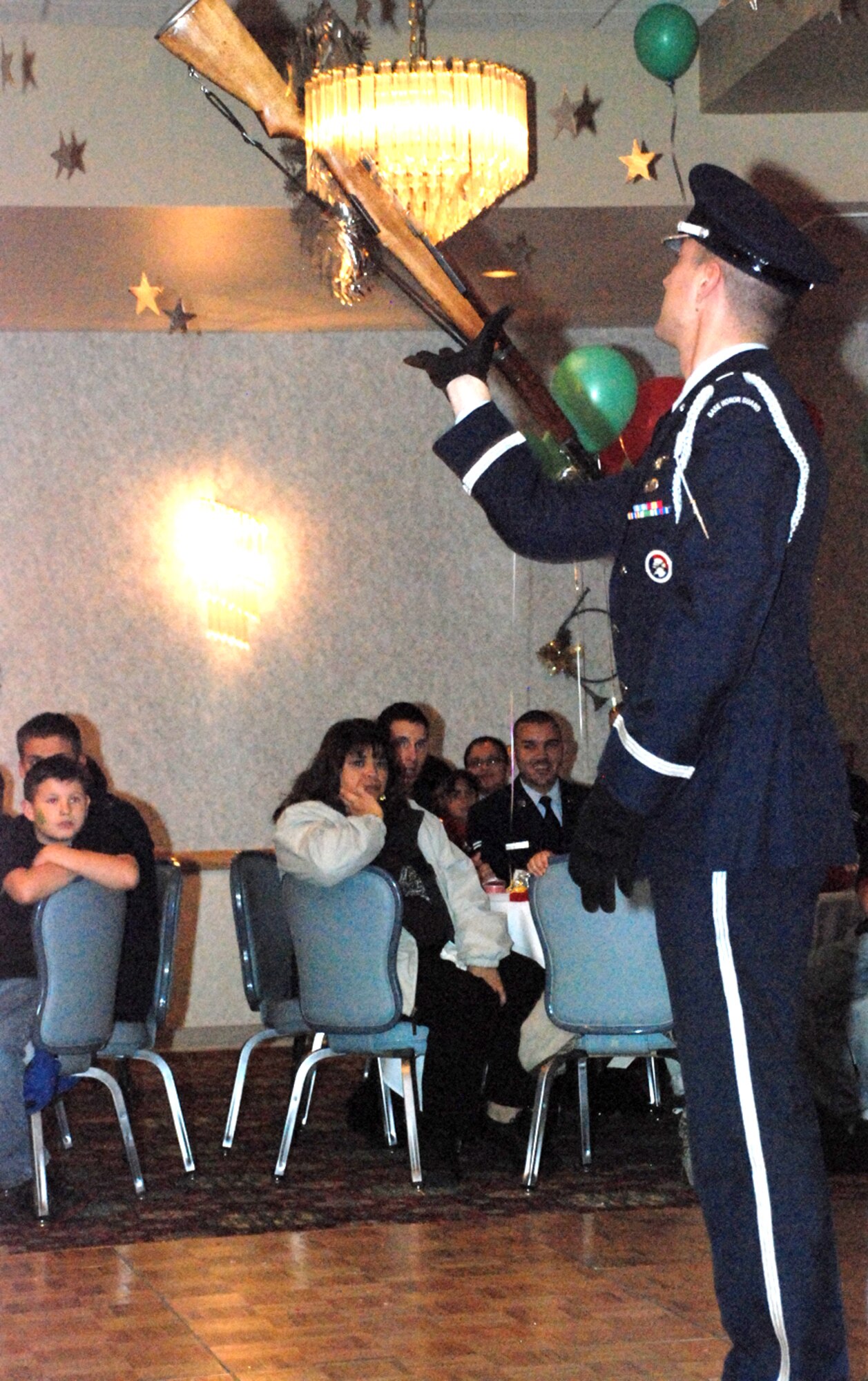 Capt. Robert Glas, 90th Operations Support Squadron, executes an honor guard M-1 rifle drill demonstration for the children during OPJ. He showed the children rifle movements, and spun and tossed the 11-pound rifle in the air.