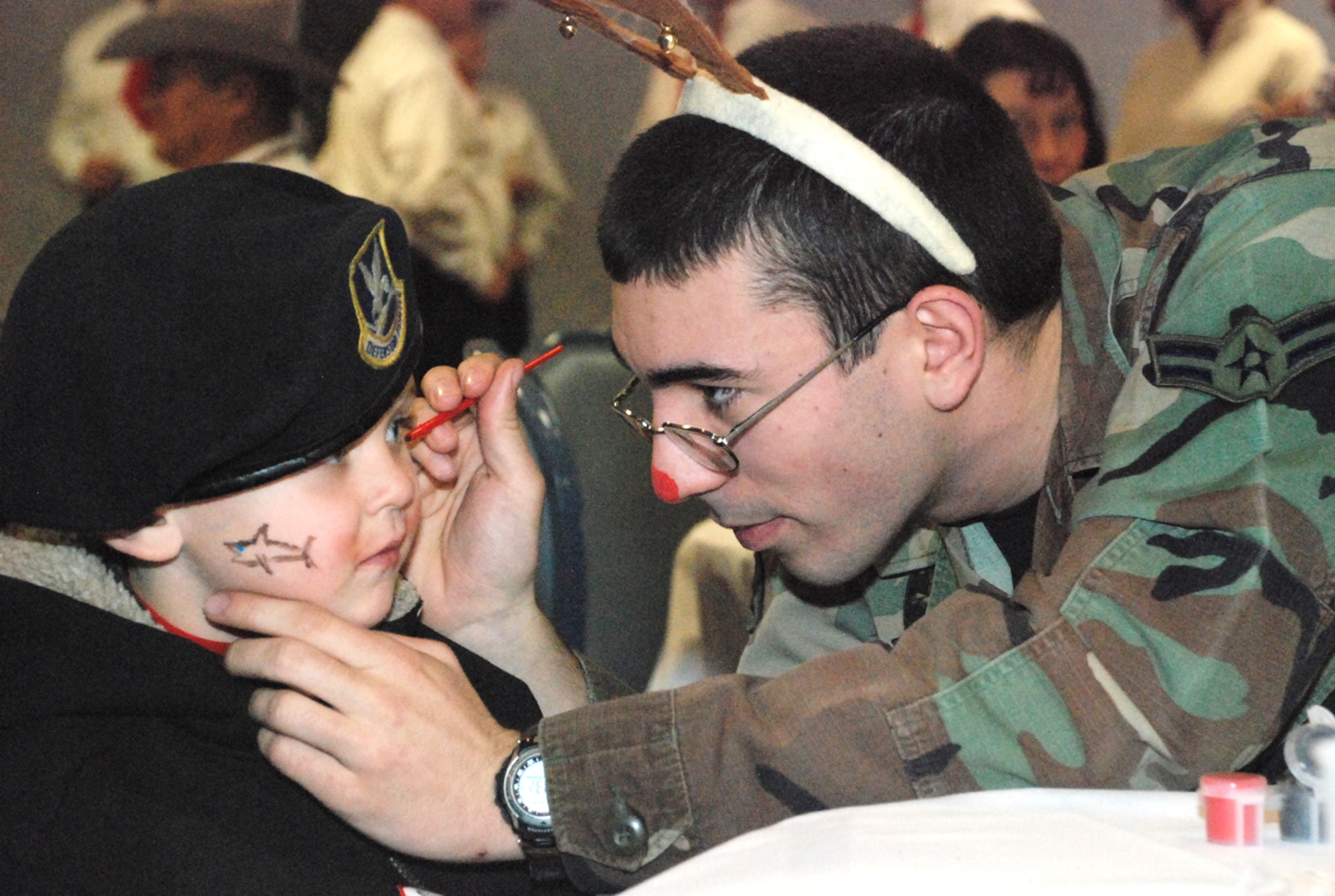 Airman 1st Class Steven Pyott, 790th Missile Security Forces Squadron, paints children’s faces during Operation Provide Joy. More than 90 children participated in the event with each having their own Airman.