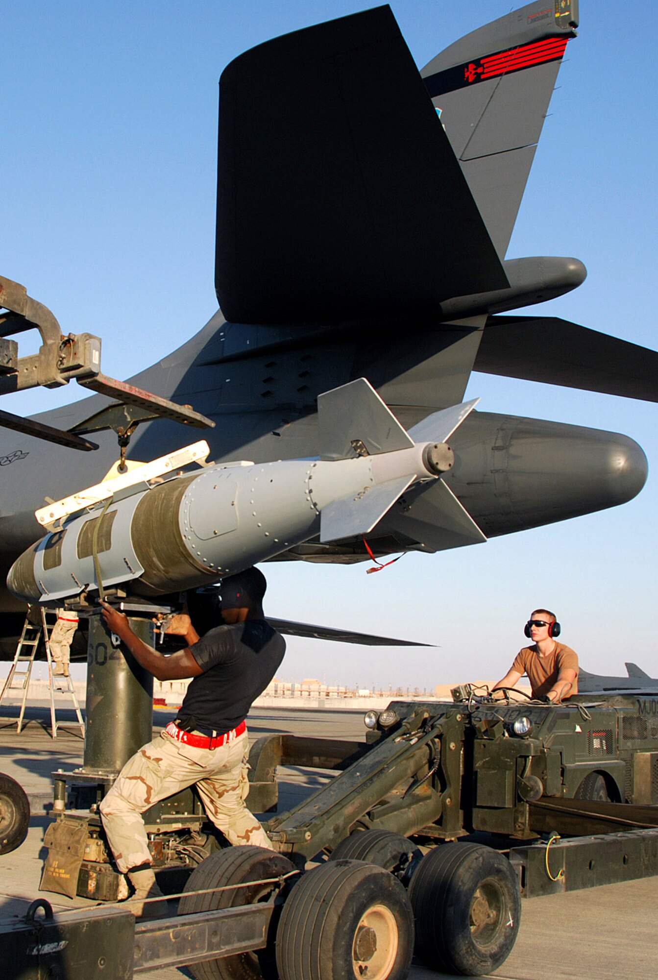 Airman 1st Class Daniel Morton secures a bomb to the ram jammer operated by Airman David Pownell Dec. 21 at a Southwest Asia air base. The two Airmen are assigned to the 379th Expeditionary Maintenance Squadron and deployed from Dyess Air Force Base, Texas. Airman Morton's home town is Anderson, S.C., and Airman Pownell is from Appleton, Wis. (U.S. Air Force photo/Staff Sgt. Douglas Olsen) 
