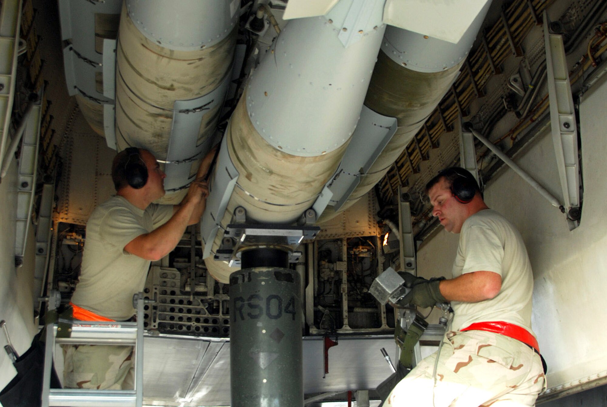 Staff Sgt. Brandon Neitz (left) and Tech. Sgt. James Sheldon load 2,000 pound bombs on a B-1B Lancer to prepare it for a mission Dec. 21 at a Southwest Asia air base. Both sergeants are assigned to the 379th Expeditionary Maintenance Squadron and deployed from Dyess Air Force Base, Texas. (U.S. Air Force photo/Staff Sgt. Douglas Olsen) 
