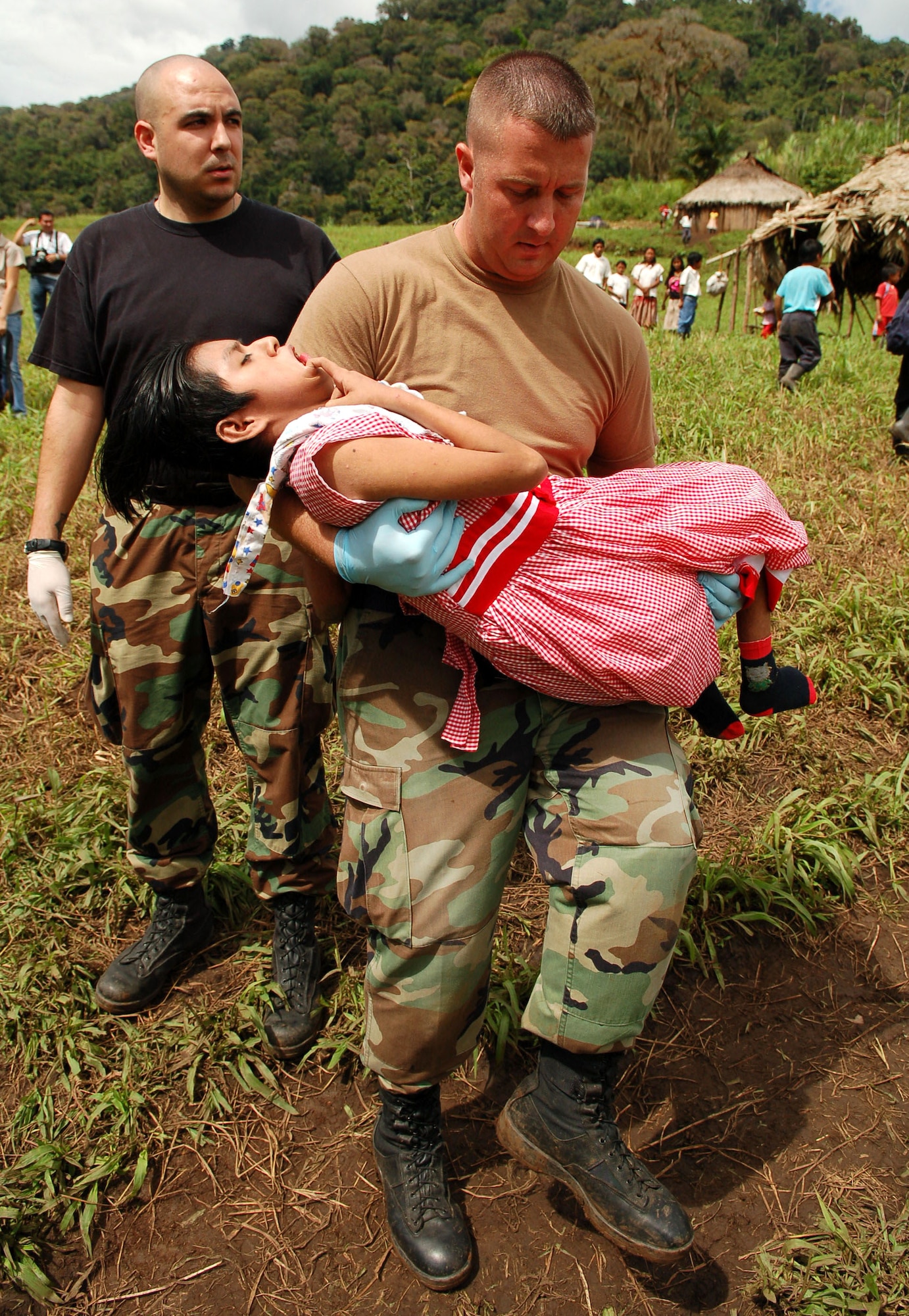 Staff Sgts. Steven Geist (left) and David Pagani take a young Costa Rican girl with cerebral palsy who has been diagnosed with pneumonia to a waiting helicopter to be air evacuated from a makeshift clinic to a hospital in Limon Dec. 18 from Piedra Mesa, Costa Rica. Sergeants Geist and Pagani are assigned to the Joint Task Force-Bravo medical element. JTF-Bravo deployed 28 servicemembers from Soto Cano Air Base, Honduras, to Costa Rica at the invitation of the country's ministry of health for a medical readiness training exercise. (U.S. Air Force photo/Staff Sgt. Austin M. May) 
