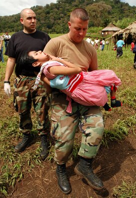 Staff Sgts. Steven Geist (left) and David Pagani take a young Costa Rican girl with cerebral palsy who has been diagnosed with pneumonia to a waiting helicopter to be air evacuated from a makeshift clinic to a hospital in Limon Dec. 18 from Piedra Mesa, Costa Rica. Sergeants Geist and Pagani are assigned to the Joint Task Force-Bravo medical element. JTF-Bravo deployed 28 servicemembers from Soto Cano Air Base, Honduras, to Costa Rica at the invitation of the country's ministry of health for a medical readiness training exercise. (U.S. Air Force photo/Staff Sgt. Austin M. May) 