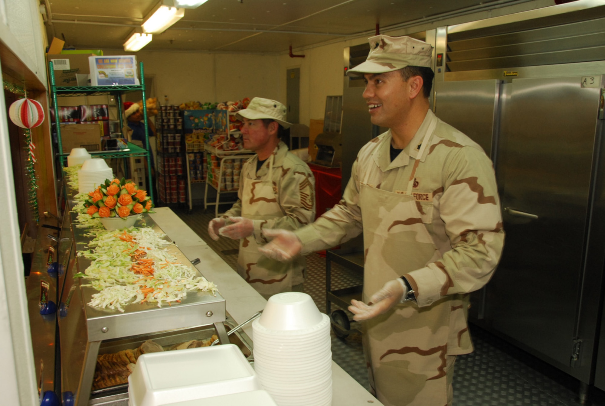 SOUTHWEST ASIA - Lt. Col. Mike Benson, 379th Expeditionary Communications Squadron and Chief Master Sgt. Arley Wheeler, 379th ECS, serve Christmas dinner to deployed troops at a Southwest Asia air base Dec. 25. (U. S. Air Force photo/Staff Sgt. Douglas Olsen)