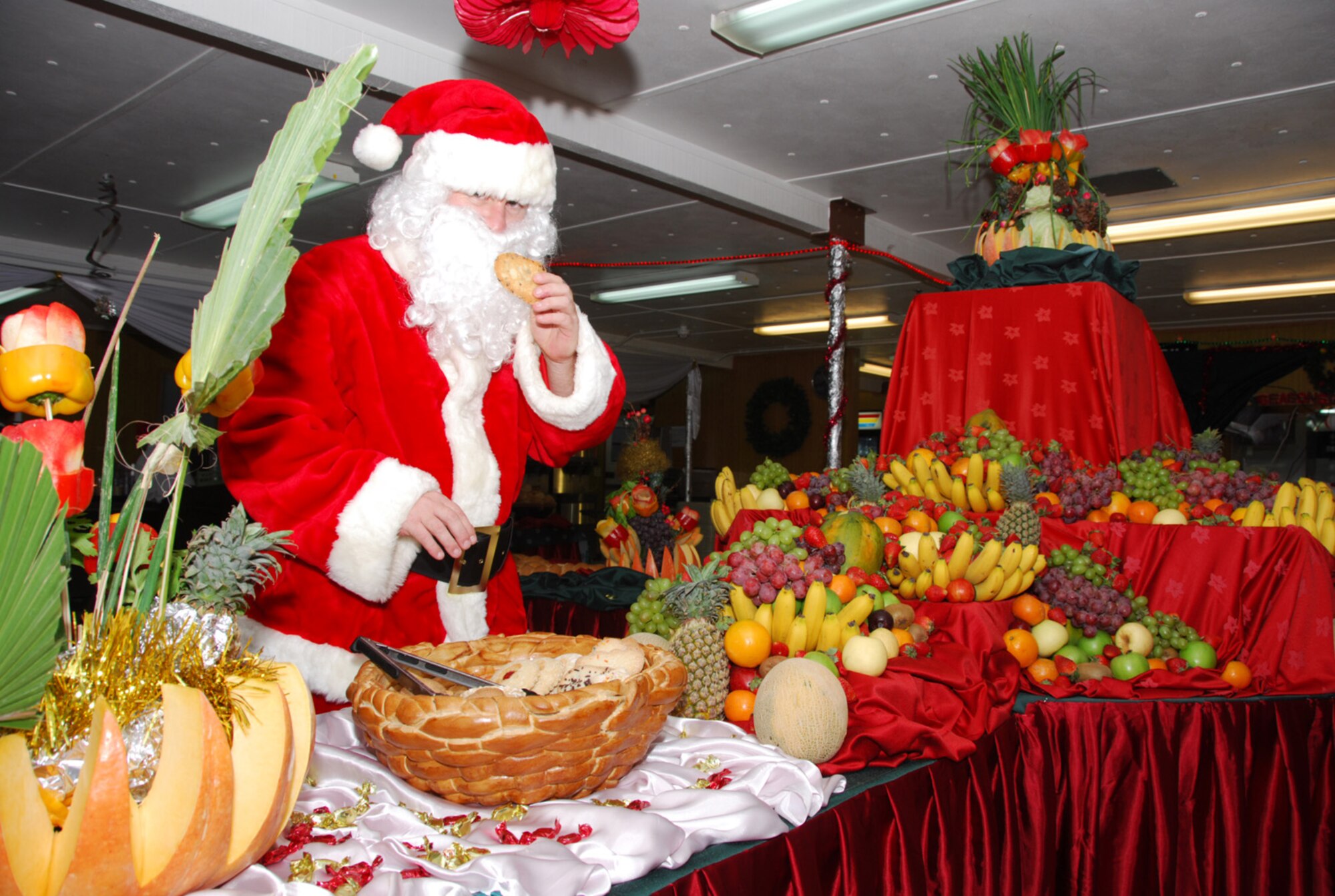 SOUTHWEST ASIA - Santa Claus, also known as  Master Sgt. Joe Ennen, 379th Expeditionary Services Squadron, is caught red-hatted snitching a cookie in the Independence Dining Facility at a Southwest Asia air base Dec. 25. Sergeant Ennen donned the suit early in the day and played The Jolly Elf around the base throughout the day, spreading Christmas cheer and posing for many photos with the folks of the base. (U. S. Air Force photo/Staff Sgt. Douglas Olsen)