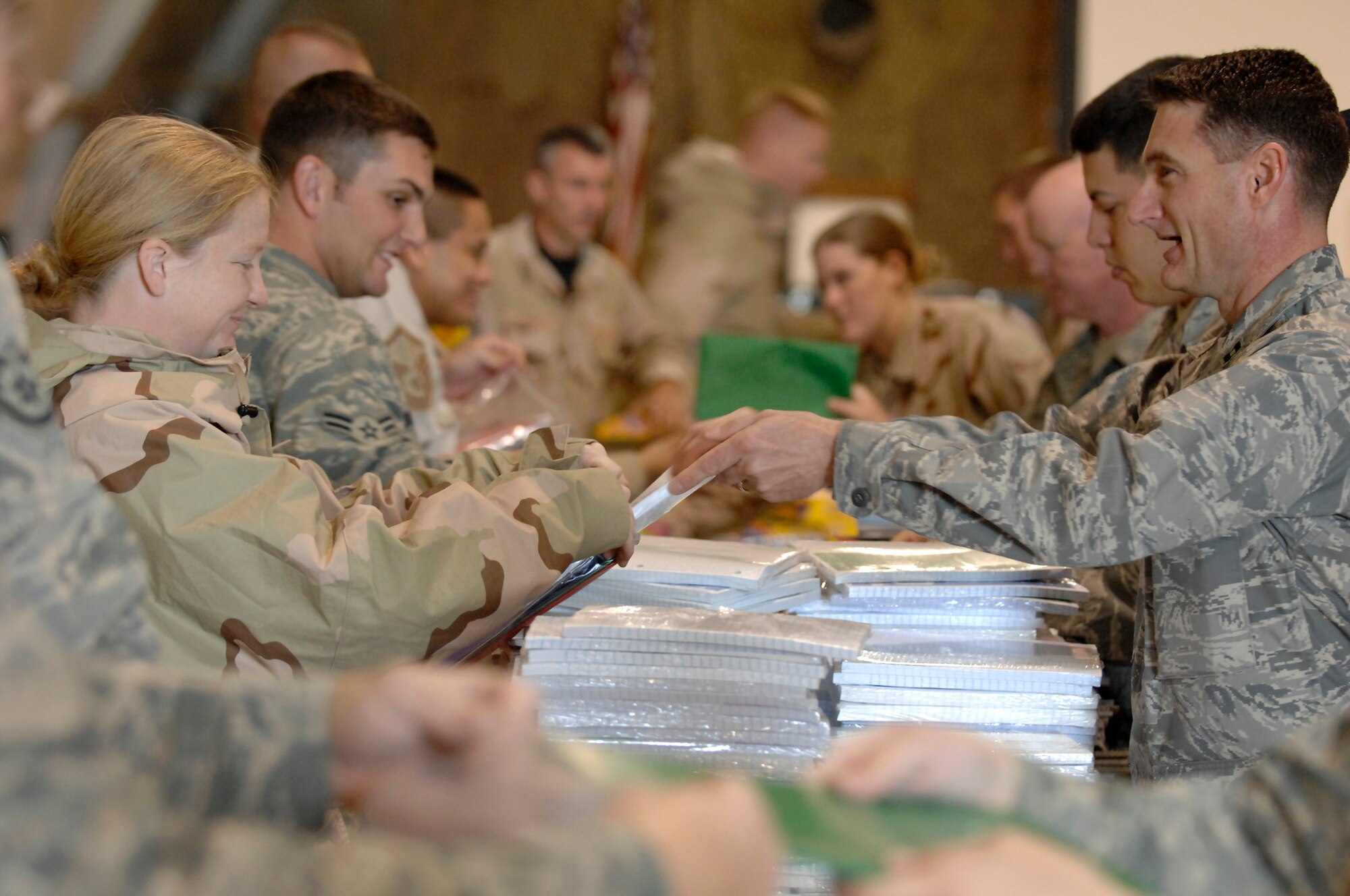 ALI AIR BASE, Iraq -- Chaplain (Capt.) Robert Borger hands out packs of paper Dec. 22 in support of Operation Iraqi Child led by the Focus 5/6 and Top 3 councils. In just over a month, Airmen on base collected thousands of school supply items, soccer balls, stuffed animals and toys from back home. Airmen from across all eight squadrons spent a few hours sorting all the donated items which the office of special investigations will give to Iraqi families in the An Nasiriyah area villages. Chaplain Borger is assigned to the 407th Air Expeditionary Group and is deployed from Hickam Air Force Base, Hawaii. (U.S. Air Force photo/Airman 1st Class Jonathan Snyder)