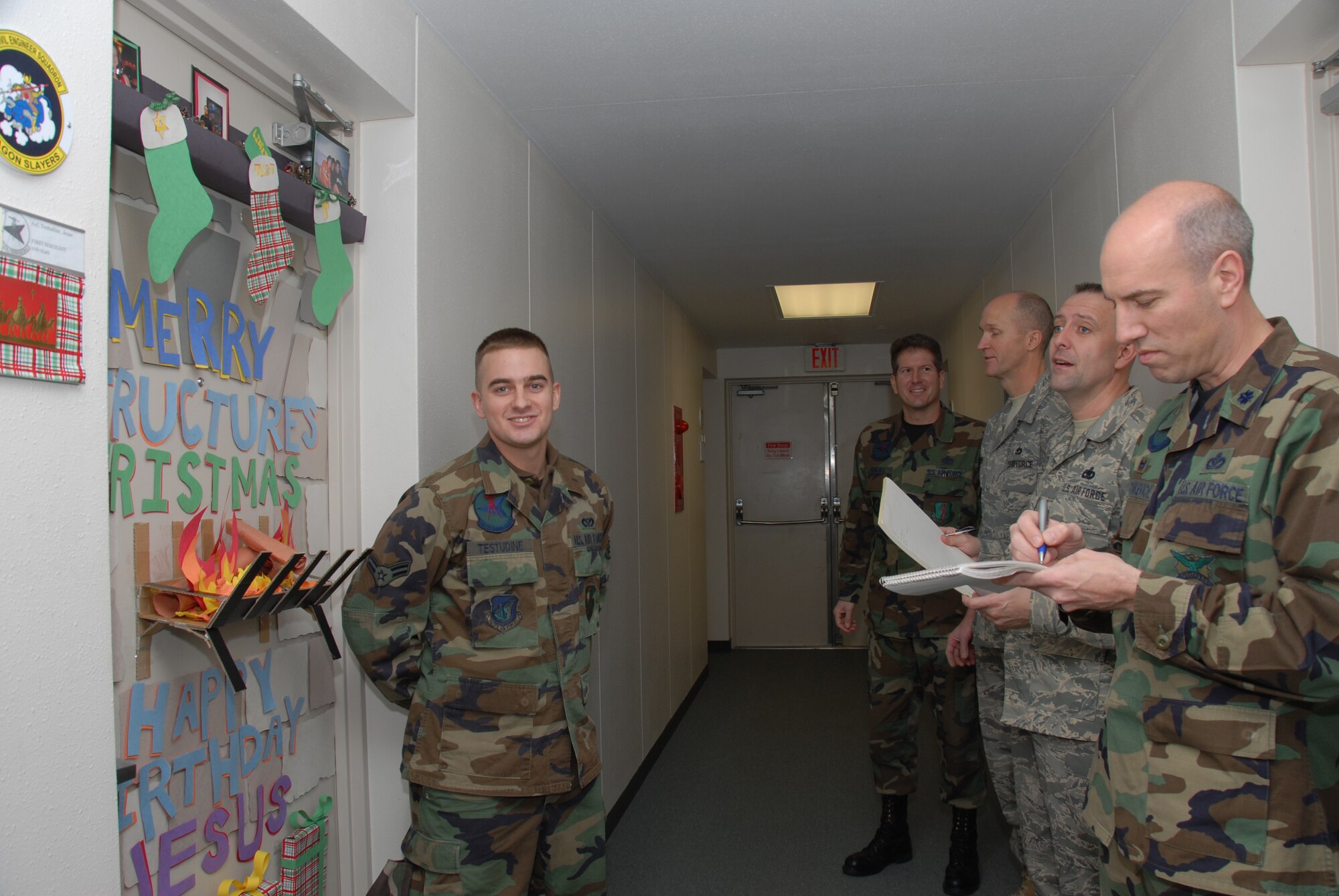 MISAWA AIR BASE, Japan -- Airman 1st Class Jesse Testudine, 35th Civil Engineer Squadron, waits by his door as Lt. Col. Joseph Marcinkevich, 35th Civil Engineer Squadron commander, and several other members of the 35th Civil Engineer Squadron judge his door during a door decorating contest here on Dec. 26, 2007.  (U.S. Air Force photo by Senior Airman Laura R. McFarlane)
