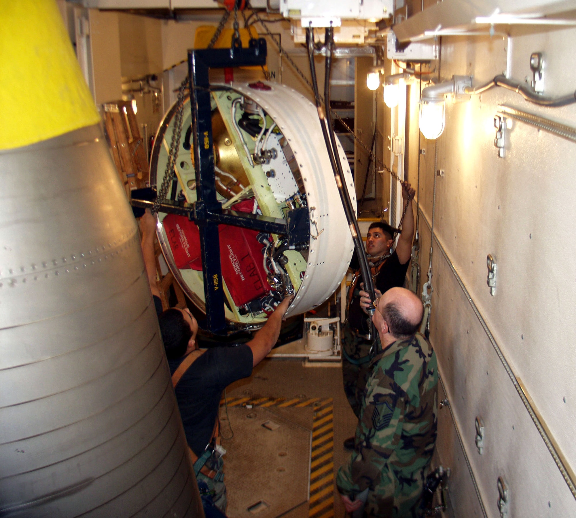 Master Sgt. Maxwell Jackson, Staff Sgt. Preston Yockeman and Senior Airman David Burress perform missile guidance system tilt procedures to maneuver the MGS to the rear of the two re-entry systems in the payload transporter van on site Dec. 4 at Malmstrom Air Force Base, Mont. Sergeant Jackson is a 341st Missile Maintenance Squadron team critical task supervisor, Sergeant Yockeman is a 341st Missile Maintenance Squadron team cageman, and Airman Burress is a 341st Missile Maintenance Squadron team top side technician. (U.S. Air Force photo)