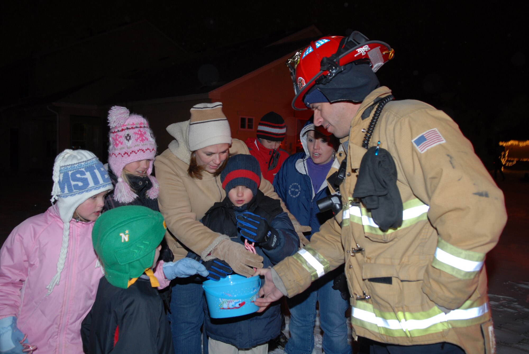 Mr. Dean Morris, a Buckley firefighter, passes out candy at the holiday parade at family housing Dec. 21. (U.S. Air Force Photo by Staff Sgt. Dallas Edwards)