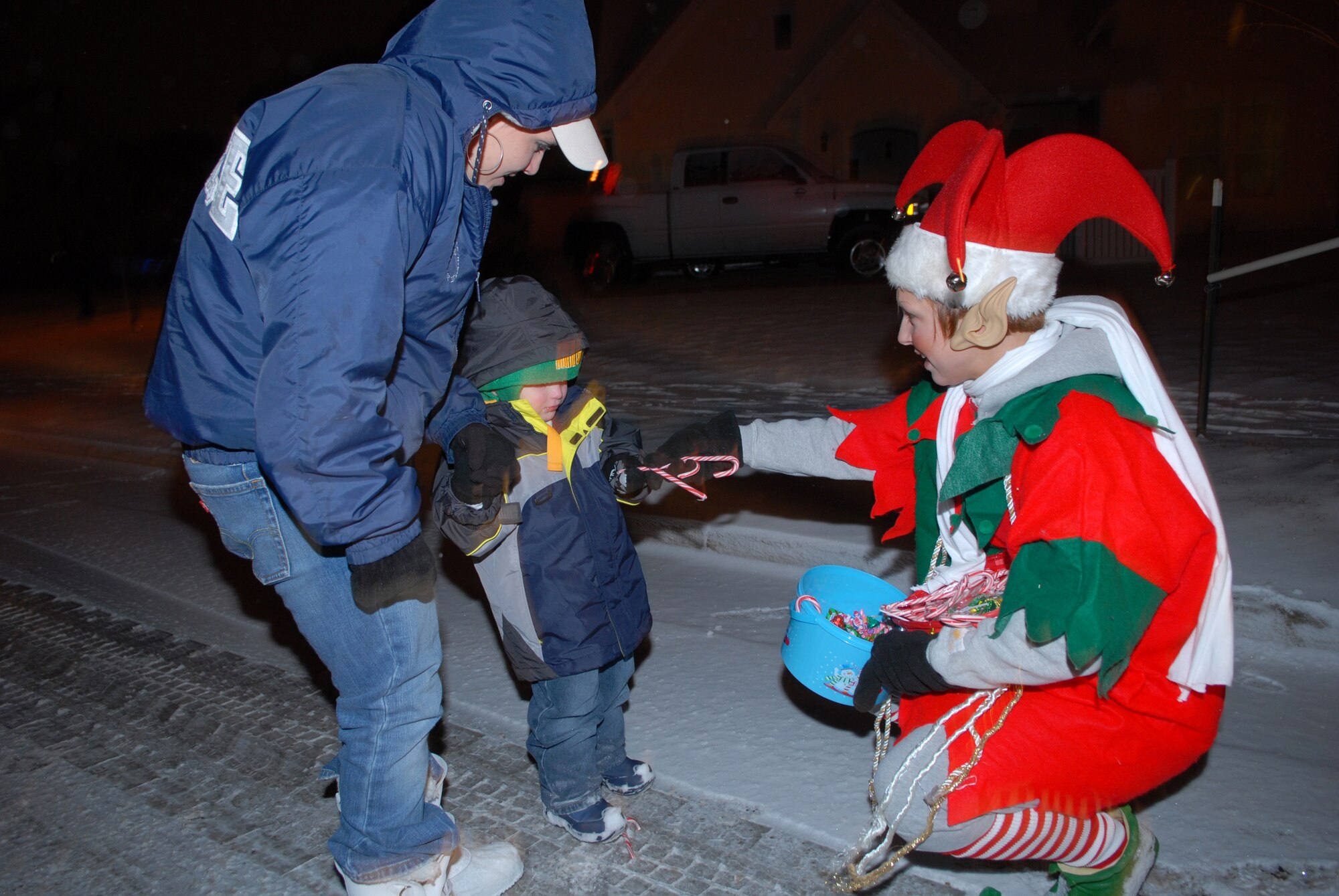 Senior Airman Emily Martin, from the 460th Civil Engineer Squadron, passes out candy at the holiday parade in family housing, Dec. 21. (U.S. Air Force photo by Staff Sgt. Dallas Edwards)