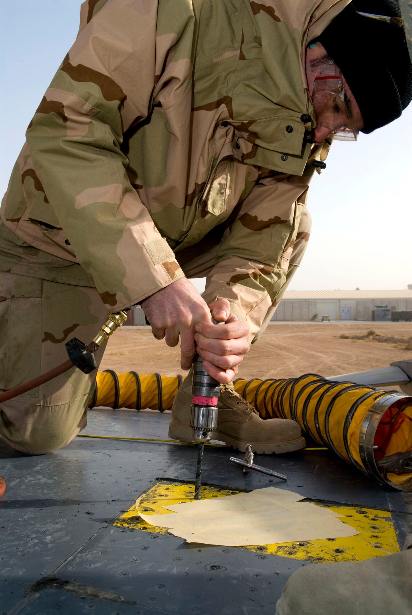 Airman 1st Class Bradley Giroux uses an air drill to remove a Davis Elliptical fastener from an F-16 Fighting Falcon Dec. 22 at Balad Air Base, Iraq. The fastener is used as an internal nut plate where bolts are not needed to hold screws in place. Airman Giroux, a 332nd Expeditionary Maintenance Squadron sheet metal technician, is deployed from Spangdahlem Air Base, Germany. (U.S. Air Force photo/Staff Sgt. Joshua Garcia) 
