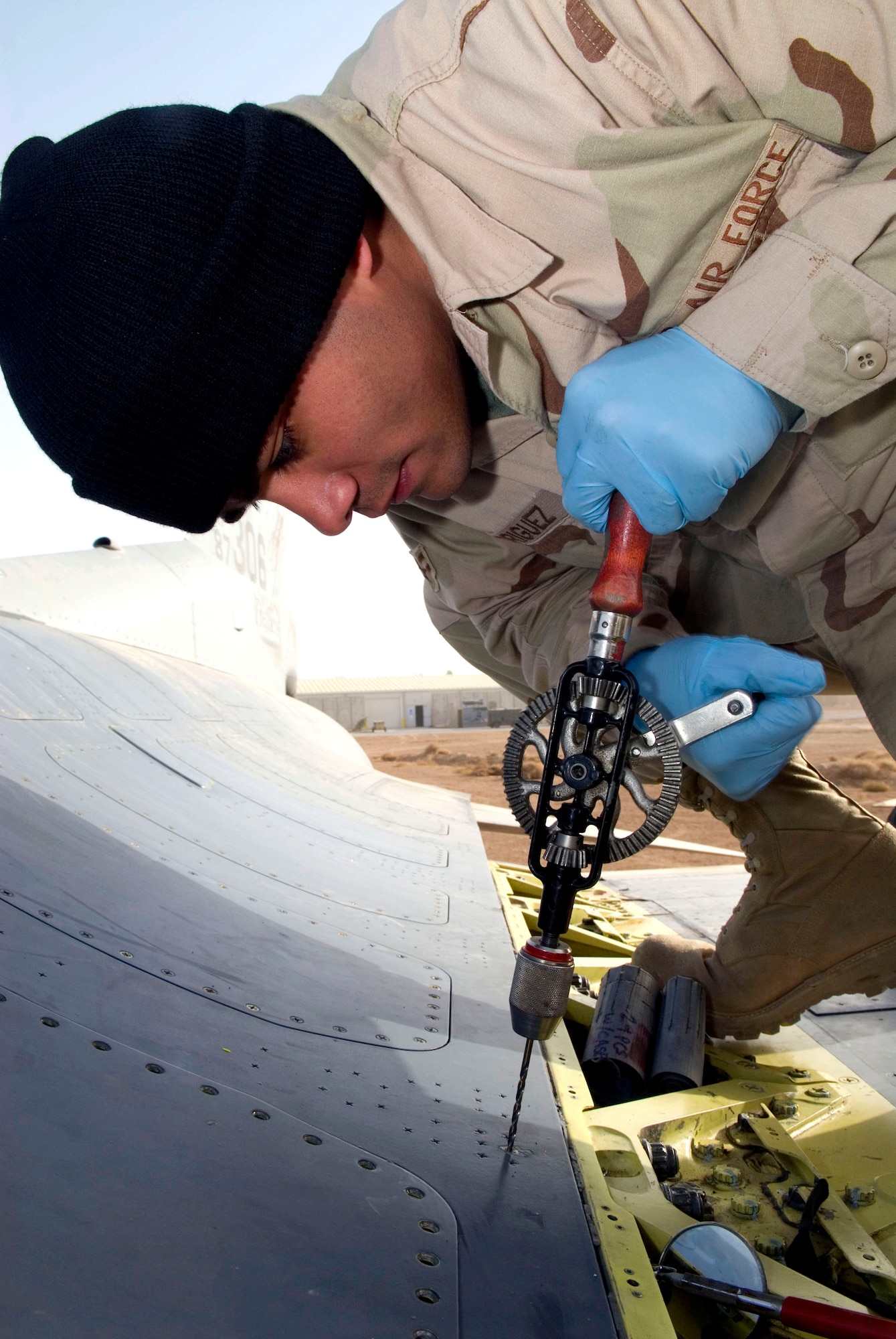 Airman 1st Class Noe Rodriguez manually drills a Hi-Lok fastener on an F-16 Fighting Falcon fuel cell Dec. 22 at Balad Air Base, Iraq. Airman Rodriguez must use manual- or air-powered tools on the aircraft fuel cells because an electric drill could ignite fuel inside the aircraft. Airman Rodriguez, a 332nd Expeditionary Maintenance Squadron sheet metal technician, is deployed from Spangdahlem Air Base, Germany. (U.S. Air Force photo/Staff Sgt. Joshua Garcia)