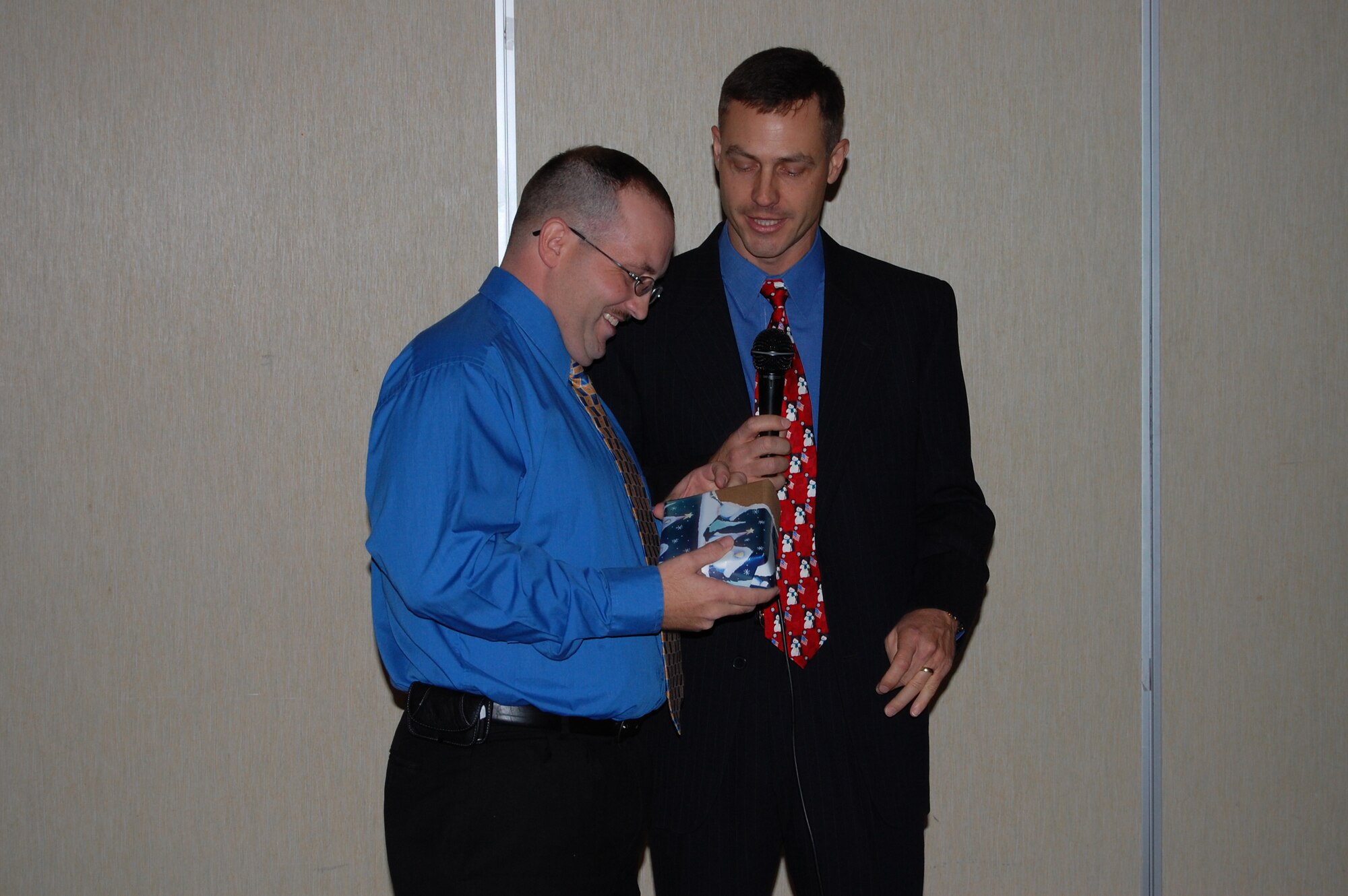Staff Sgt. David Megeath, 436th Maintenance Operations Squadron, unwrapped what he thought was a party gift from Col. Steve Harrison, 436th Airlift Wing commander,  but was actually technical sergeant stripes. Which, in his opinion, was the finest gift he could receive. He was STEP promoted at his squadron's Christmas Party Dec. 21. (U.S. Air Force photo/ Chief Master Sgt. Howard Heisey)