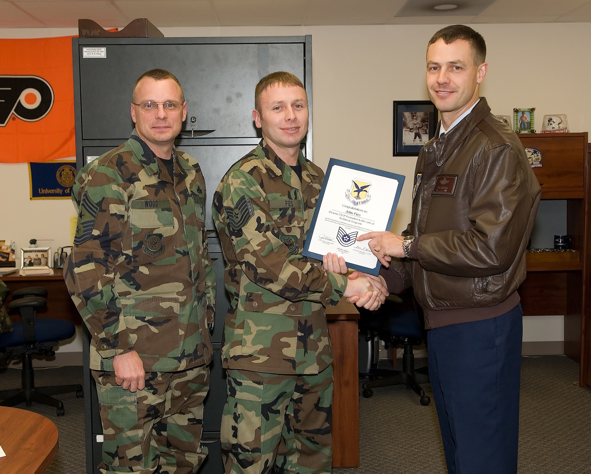Col. Steve Harrison, 436th Airlift Wing commander, and Chief Master Sgt. John Woods, 436th AW command chief, surprised Staff Sgt. John Fies, 436th Communications Squadron, with technical sergeant stripes and a STEP promotion Dec. 21. (U.S. Air Force photo/ Jason Minto)