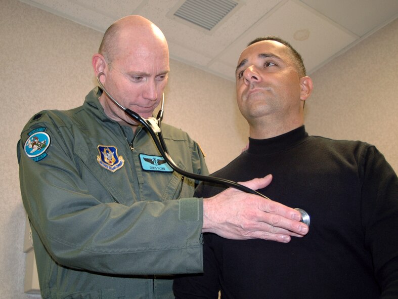 DOVER AIR FORCE BASE, Del. -- Lt. Col. Christopher Flynn, 512th Aerospace Medicine Squadron flight surgeon, conducts a physical examination on Staff Sgt. Pedro Consuegra, 512th AMDS. The doctor, who works for the U.S. Department of State as a regional medical officer in psychiatry, lives in Jordan and makes a 72-hour round trip about four times a year to serve as a reservist in the 512th Airlift Wing, Dover Air Force Base, Del. (U.S. Air Force photo/Capt. Marnee A.C. Losurdo)