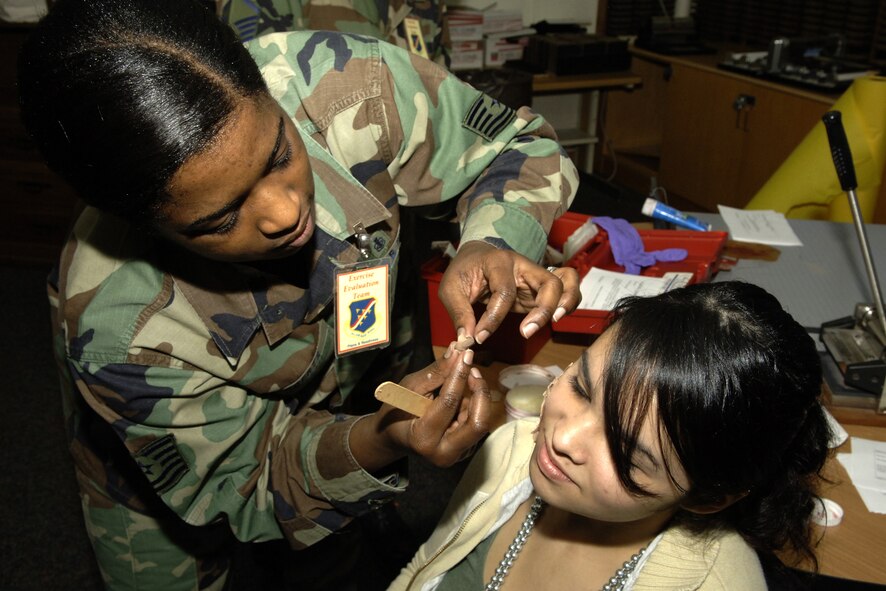 Tech. Sgt. Takeyla Roberts, 39th Medical Group, applies moulage to Angelina Aguirre, daughter of Tech. Sgt. Ulises Aguirre, 39th Maintenance Squadron. Students of the Incirlik Unit High school spent the afternoon playing victims during the Mass Accident Response Exercise held at the school Dec. 17. (U. S. Air Force photo by Airman 1st Class Nathan Lipscomb)