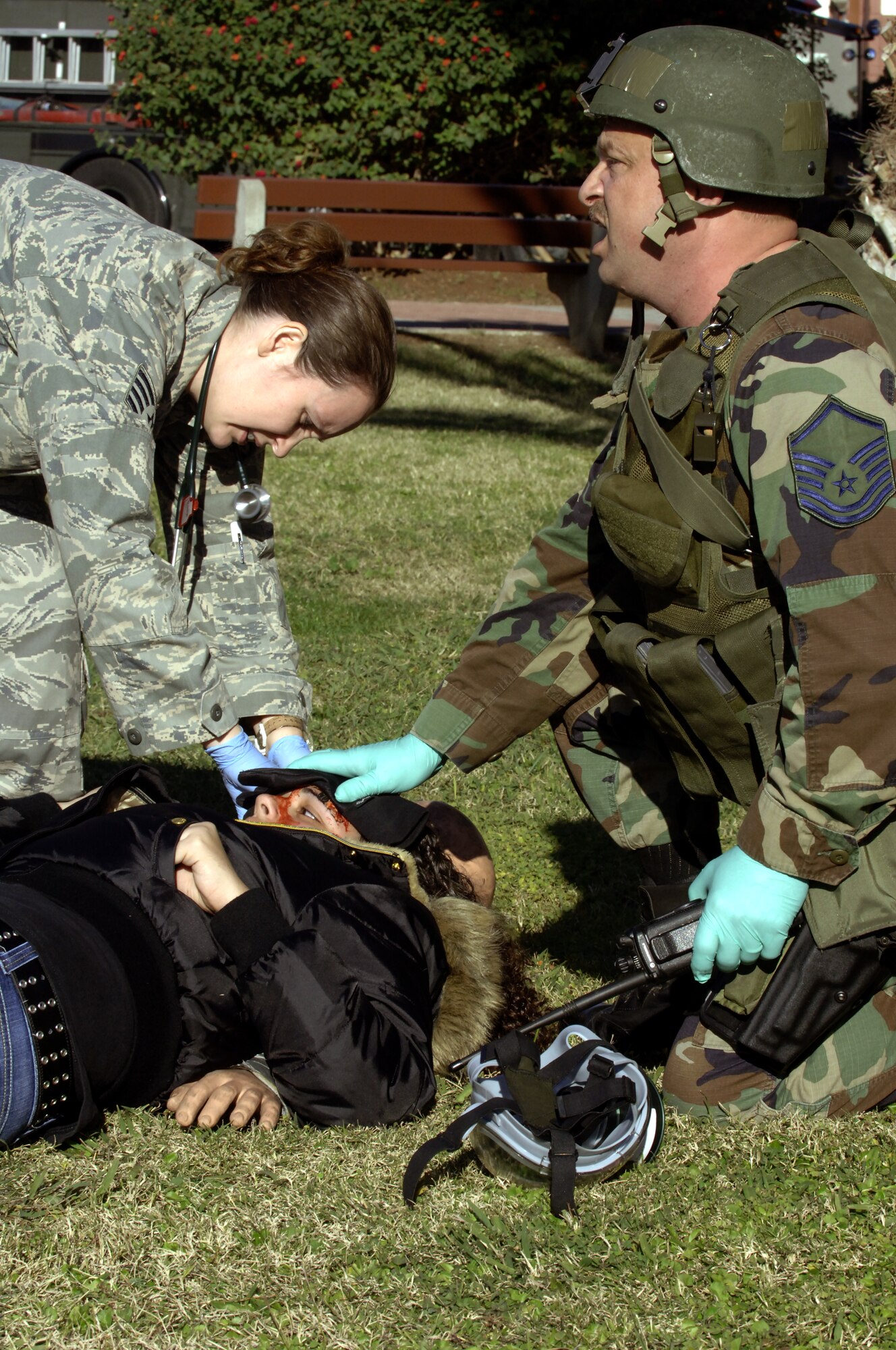 Staff Sgt. Richelle Morey, left, 39th Medical Group Medical Service technician, helps Master Sgt. David Cohan, right, 39th Security Forces flight chief, dress the simulated head injury of Gabrielle Gomez, daughter of Michelle Gomez, during the Mass Accident Response Exercise Dec. 17. Members of the 39th MDG, 39th SFS and Incirlik Fire Department worked together to ensure all those who suffered "injury" were treated. (U. S. Air Force photo by Airman 1st Class Nathan Lipscomb)