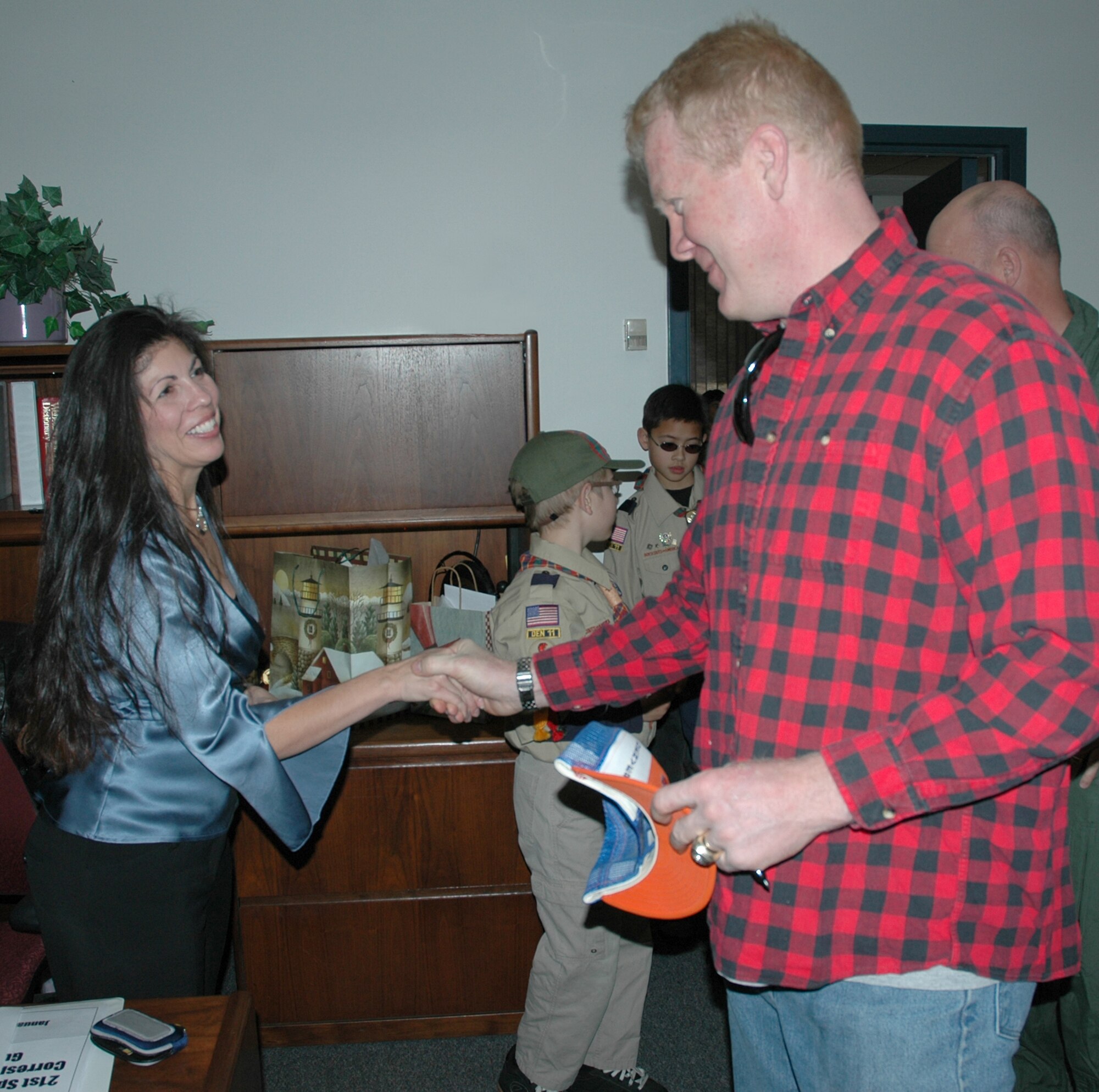 Karl Mecklenburg, former Denver Broncos linebacker from 1983 to 1994, shakes hands with Milissa Passig Dec. 21. Mr. Mecklenberg, known during those years as the ‘Iceberg,’ toured the 21st SW and the Cheyenne Mountain Complex with local Cub Scout Pack 461 from Denver, where the young scouts learned about the space wing’s mission and the role of Cheyenne Mountain in protecting the United States. (U.S. Air Force photo illustration/Senior Airman Stephen Collier)