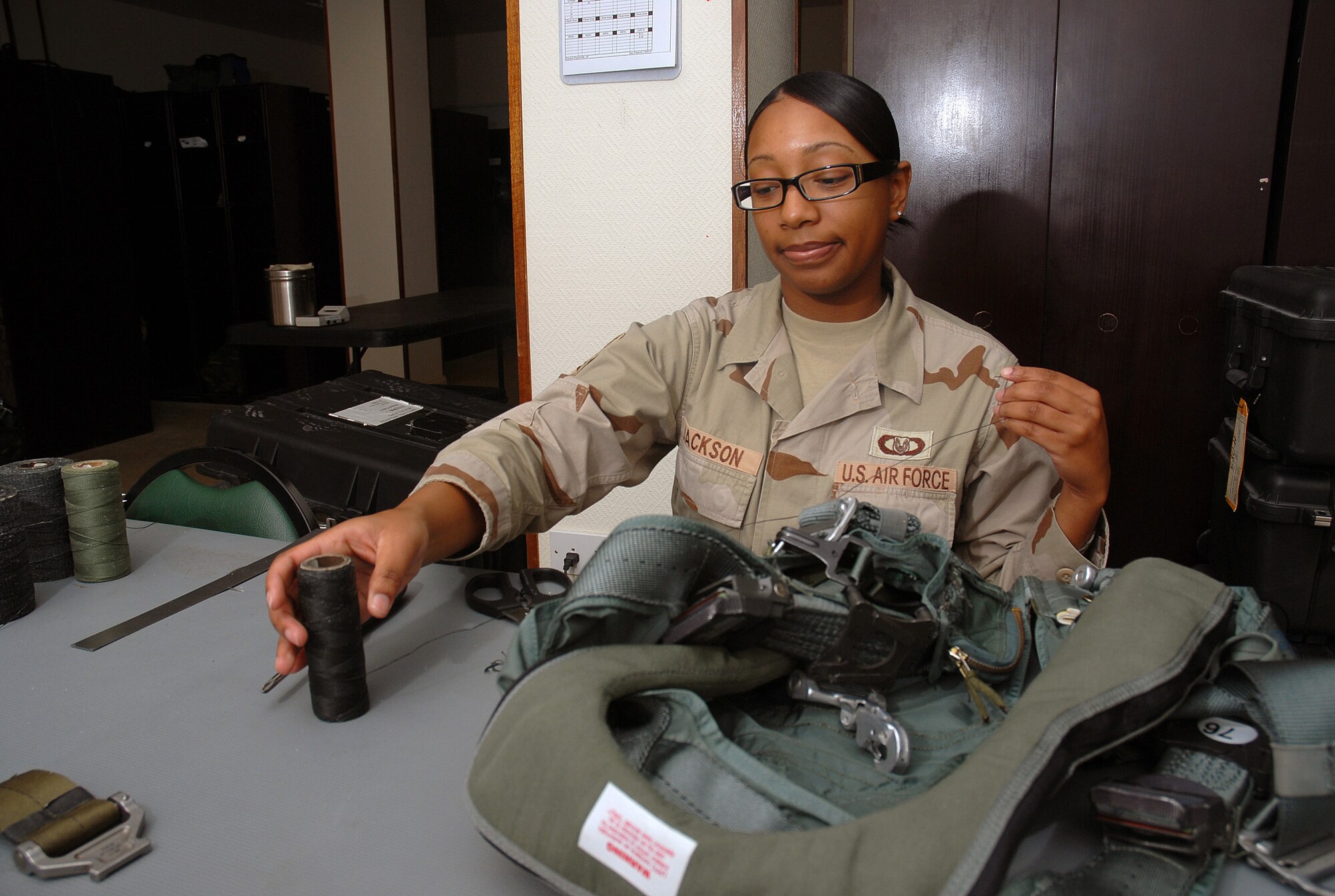 SOUTHWEST ASIA - Staff Sgt. Montrice Jackson, 379TH Operational Support Squadron aircrew life support technician, readies a torso harness for B-1B aircrew members at a Southwest Asia air base Dec. 19. Sergeant Jackson has been selected as a Warrior of the Week by her supervisor. She is deployed from Dyess Air Force Base, Texas. (U. S. Air Force photo/Staff Sgt. Douglas Olsen)