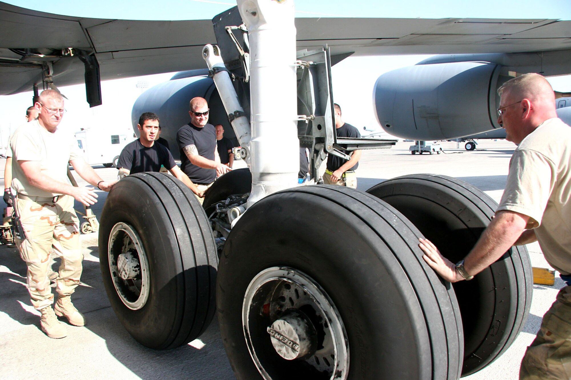 KC-135 Stratotanker maintainers move the main landing gear strut carefully to ensure all four wheels travel the same distance so when the strut is pushed back into place it will line up exactly Dec. 21. If this process is not done carefully it is difficult to re-secure the gear to the aircraft. The Airmen are assigned to the 380th Expeditionary Aircraft Maintenance Squadron and deployed from the 22nd Aircraft Maintenance Squadron at McConnell Air Force Base, Kansas. (U.S. Air Force photo/Master Sgt. Ruby Zarzyczny)