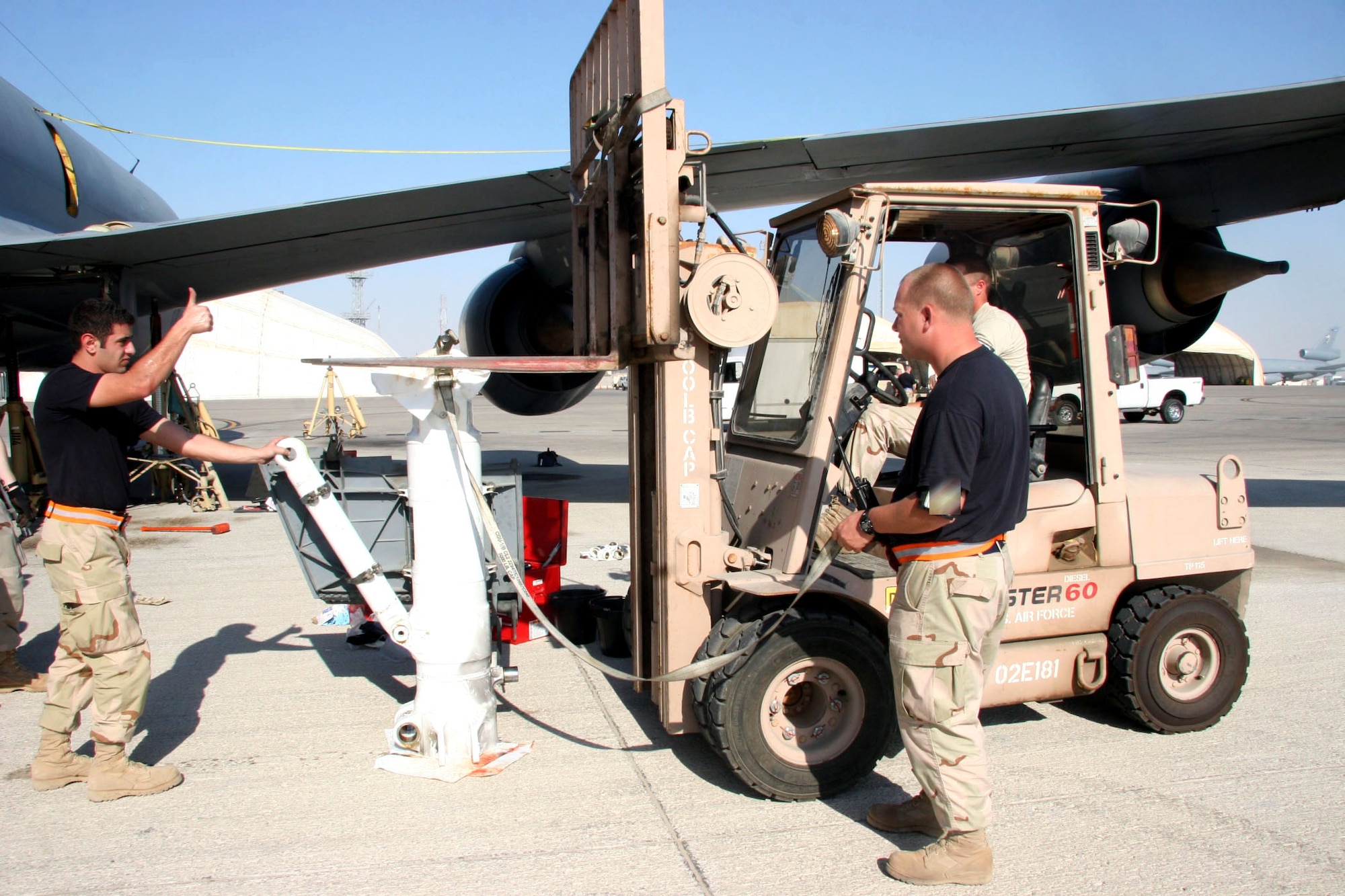 Staff Sgt. Mohammed Abouhesham (left) and Tech. Sgt. Nathan Darnell spot while Tech. Sgt. Jeremy Polk uses a fork lift to carefully lower the upper landing gear strut cylinder of a KC-135 Stratotanker to the ground Dec. 21. The Airmen are assigned to the 380th Expeditionary Aircraft Maintenance Squadron and deployed from the 22nd Aircraft Maintenance Squadron at McConnell Air Force Base, Kansas. (U.S. Air Force photo/Master Sgt. Ruby Zarzyczny) 