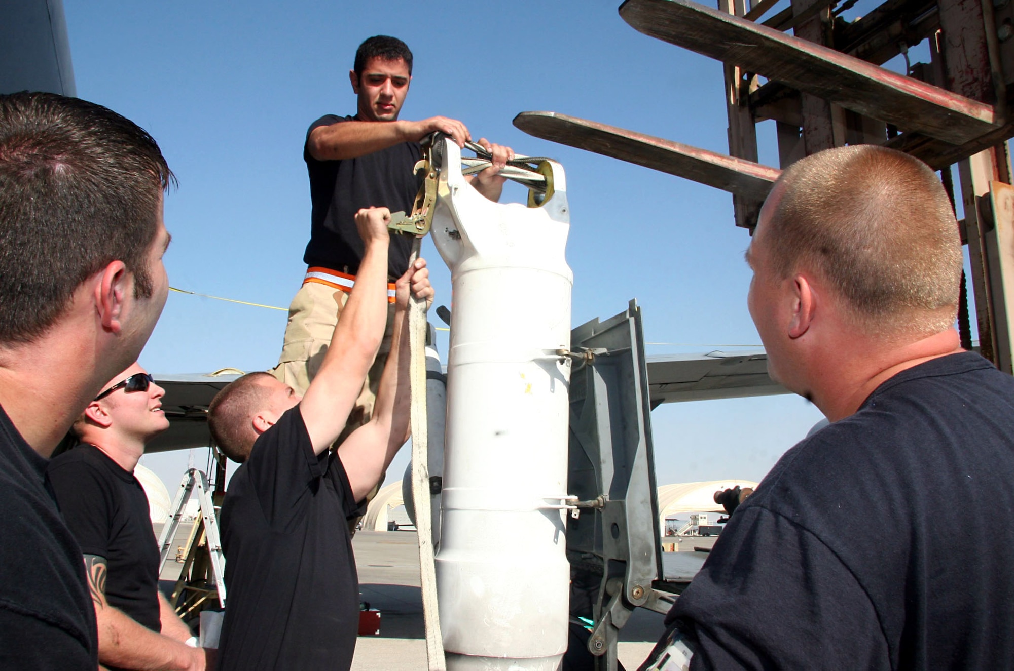 Staff Sgt. Mohammed Abouhesham (top) and Staff Sgt. Brett H. W. Wanner (below) prepare to separate the right main landing gear side strut on a KC-135 Stratotanker Dec. 21.  The Airmen are assigned to the 380th Expeditionary Aircraft Maintenance Squadron and deployed from the 22nd Aircraft Maintenance Squadron at McConnell Air Force Base, Kansas. (U.S. Air Force photo/Master Sgt. Ruby Zarzyczny)