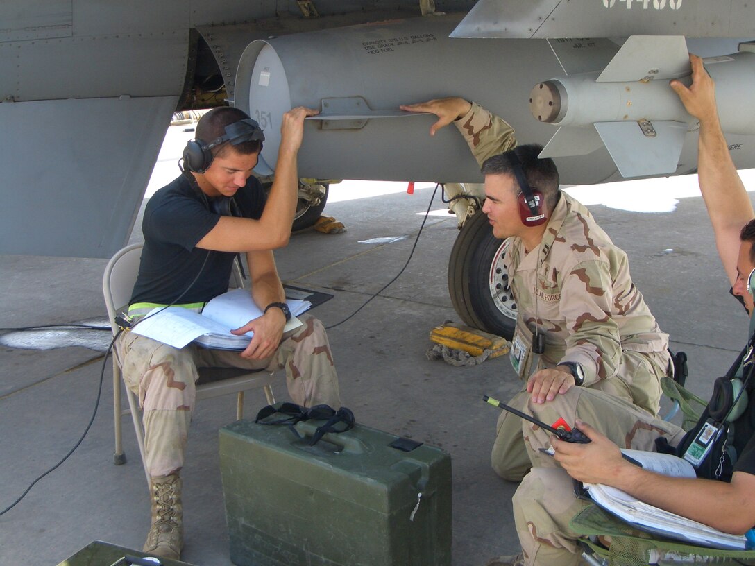 Chaplain (Maj.) Ted Nicholson (center) prays with 332nd Air Expeditionary Wing maintenance troops at Balad Air Base, Iraq. During his deployment, he experienced different situations including helping out wounded soldiers at the Air Force Theater Hospital. (U.S. Air Force Photo)