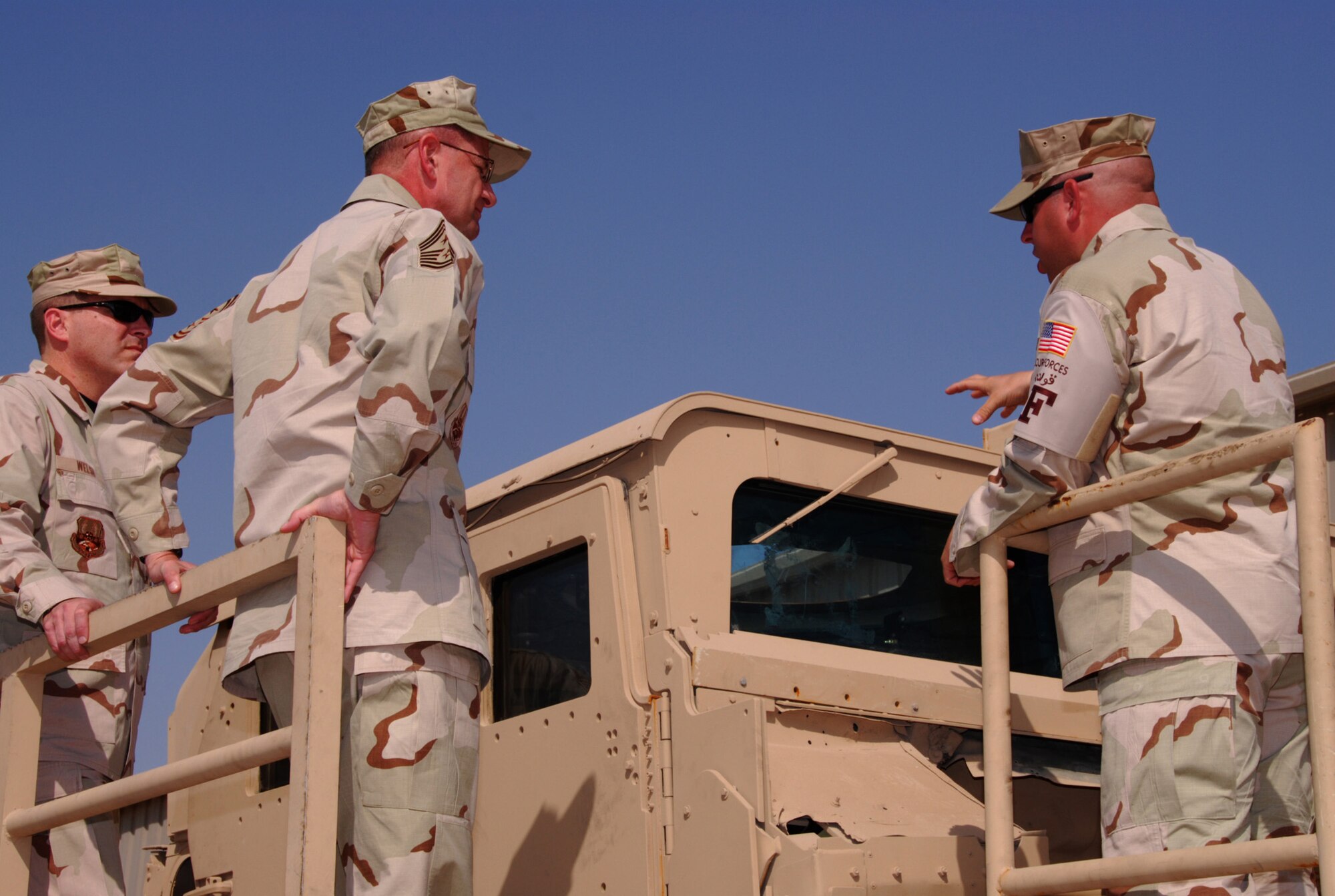 SOUTHWEST ASIA - Chief Master Sgt. Lloyd Hollen, 379th Air Expeditionary Wing command chief, listens as Tech. Sgt. Thomas Williamson explains the High Mobility Multi-purpose Wheeled Vehicle (HMMWV) Egress Assistance Training at an Army camp in Southwest Asia recently. (U.S. Air Force photo/Staff Sgt. Doug Olsen)