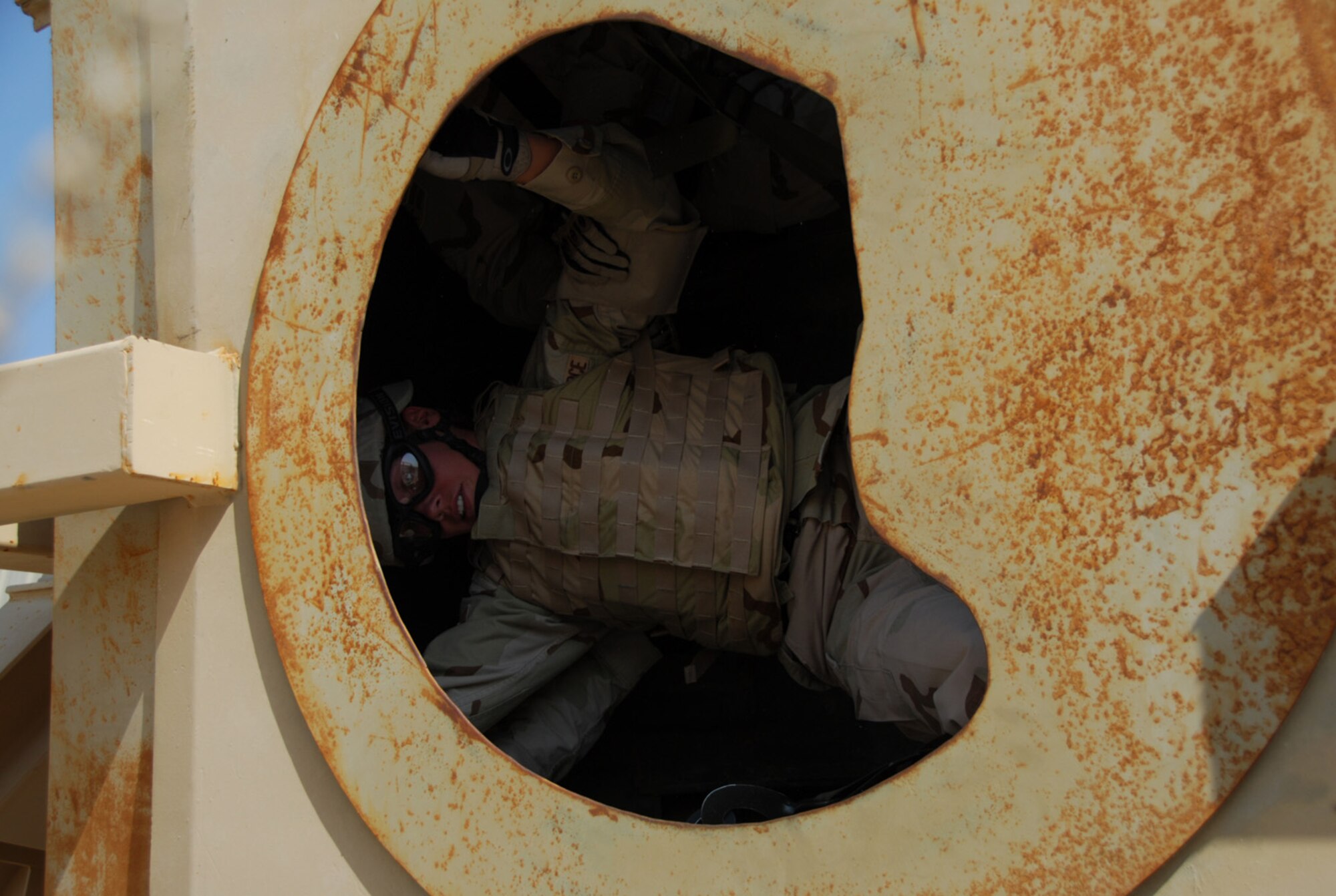 SOUTHWEST - A 379th Expeditionary Security Forces Squadron defender is held inside the rolling trainer by her comrades during High Mobility Multi-purpose Wheeled Vehicle (HMMWV) Egress Assistance Training at an Army camp in Southwest Asia recently. (U.S. Air Force photo/Staff Sgt. Doug Olsen)