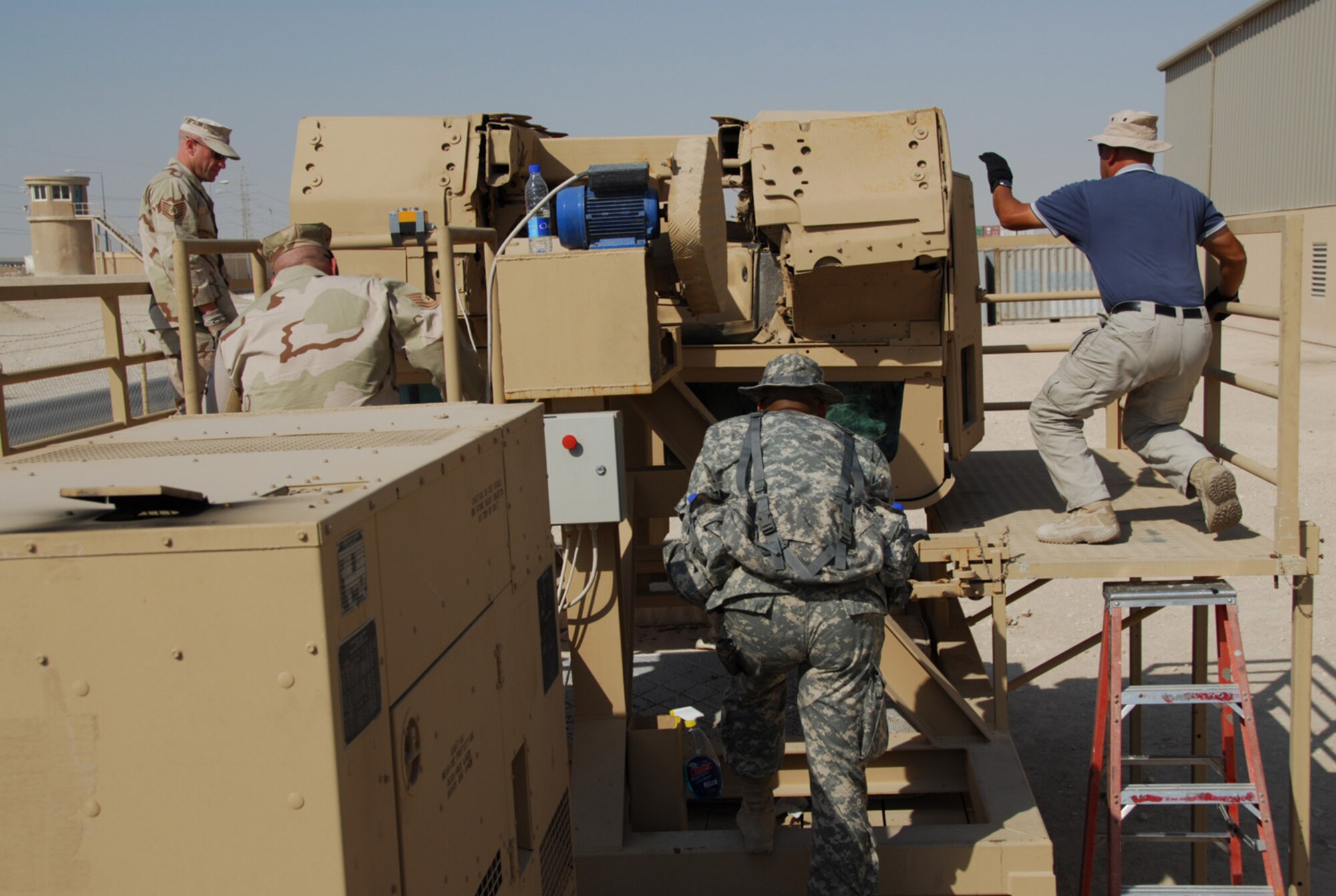 SOUTHWEST ASIA - Members of the 379th Expeditionary Security Forces Squadron take part in High Mobility Multi-purpose Wheeled Vehicle (HMMWV) Egress Assistance Training at an Army camp in Southwest Asia recently. Tech Sgt. Noah Coon, Tech Sgt. Thomas Williamson, Staff Sgt. Jose Chun and Staff Sgt. Kyle Torres stand by the inverted trainer to assist trainees inside. (U.S. Air Force photo/Staff Sgt. Doug Olsen)