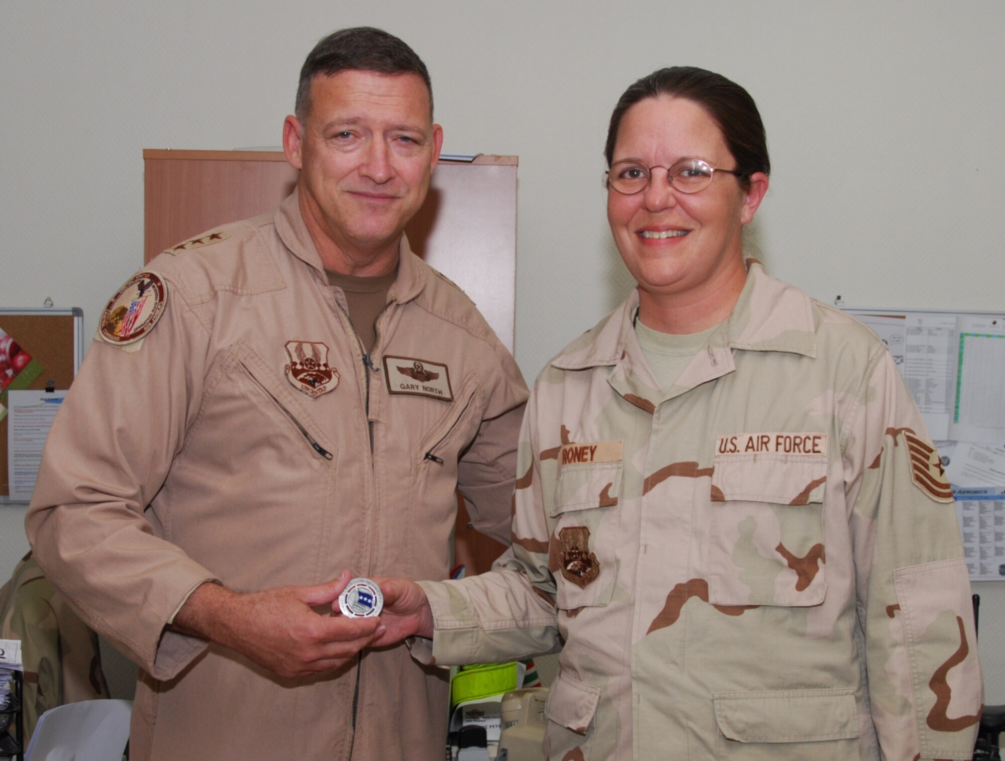 Tech. Sgt. Ashley Roney, 71st Medical Group, who is currently deployed with the 379th Expeditionary Medical Group, is coined by Lt. Gen. Gary North, 9th Air Forces and US Central Air Forces commander, during the generals visit to a Southwest Asia air base Dec. 23. The general was visiting deployed servicemembers during the holiday season. (U.S. Air Force photo by Staff Sgt. Douglas Olsen)