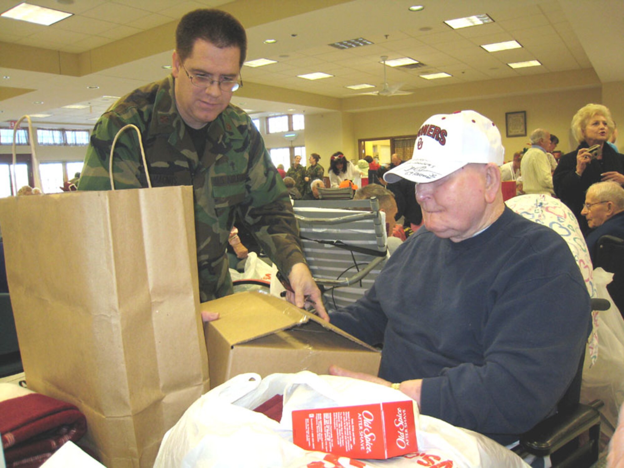 507th Air Refueling Wing Chaplain (Maj.) Dwight Magnus assists one of the Veteran Center residents in opening up his Christmas presents.  Reservists gathered and presented gifts for 294 Center residents.