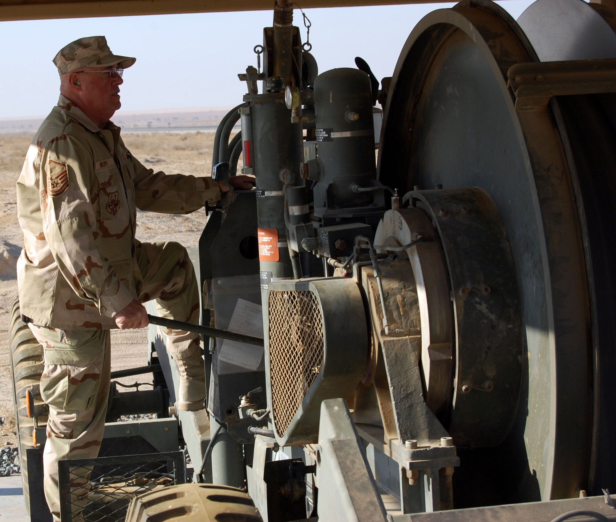 SOUTHWEST ASIA -- Master Sgt. Robert Murphy engages the rewind engine to retrieve the aircraft barrier tape Dec. 27 at an air base in the Middle East.  Sergeant Murphy is a 386th Civil Engineer Squadron barrier maintenance technician from the Portland Air National Guard, Ore.  (Air Force photo\Staff Sgt. Phillip Butterfield)