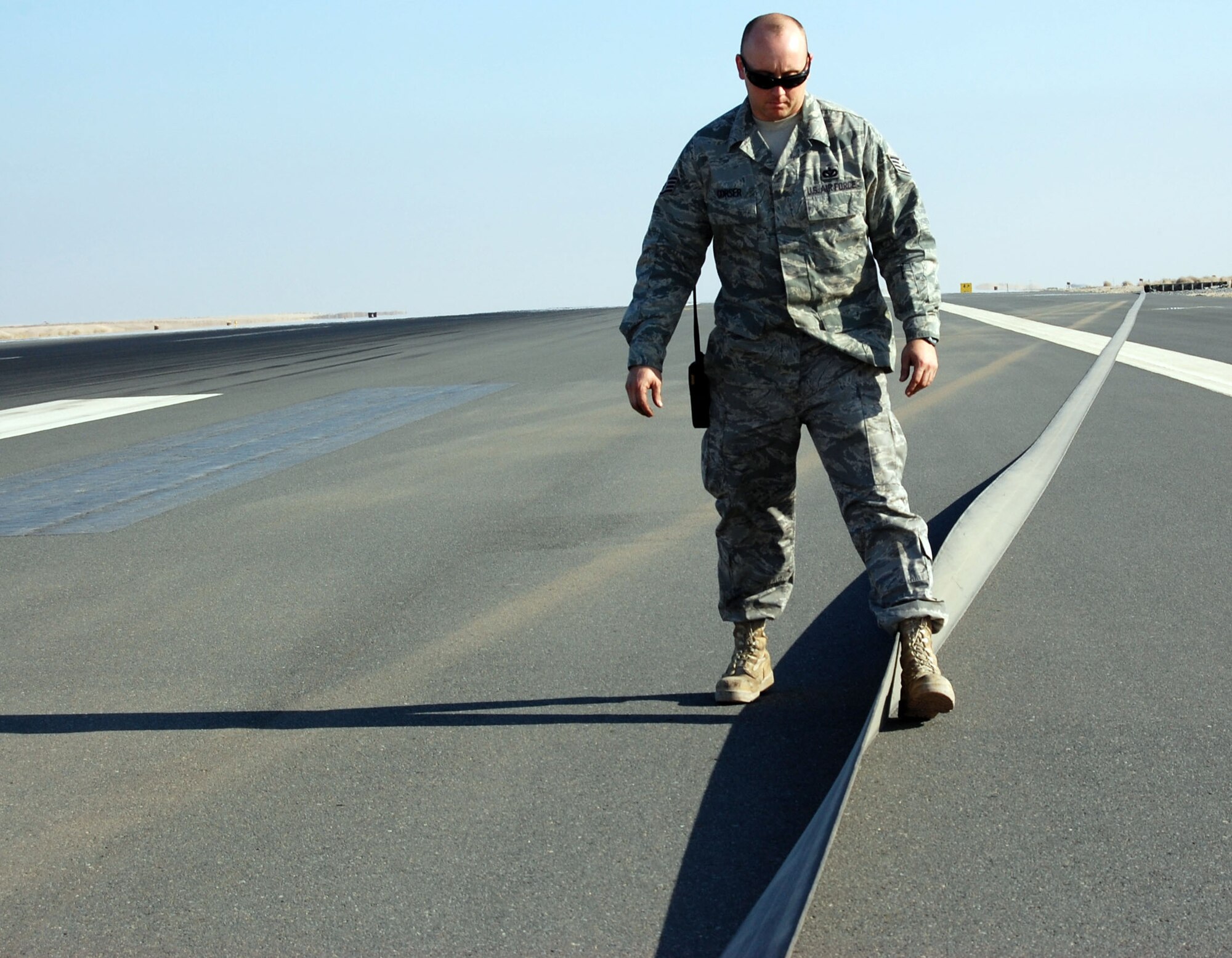 SOUTHWEST ASIA – Staff Sgt. Michael Corser walks the tape after the barrier was engaged Dec. 27 at an air base in the Middle East.  Post-barrier inspections are used to ensure there is no damage to the tape before being returned to service. Sergeant Corser is a 386th Civil Engineer Squadron barrier maintenance technician from Langley Air Force Base, Va. (Air Force photo\Staff Sgt. Phillip Butterfield)