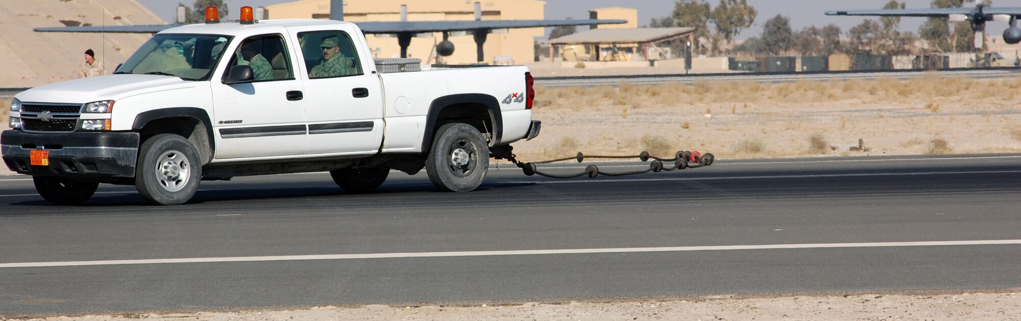 SOUTHWEST ASIA – Airmen with the 386th Civil Engineer Squadron pull a cable aircraft barrier across the runway Dec. 27 at an air base in the Middle East. The cable barrier system is used to stop aircraft equipped with tail hooks when they’re unable to stop on their own. (Air Force photo\Staff Sgt. Phillip Butterfield)