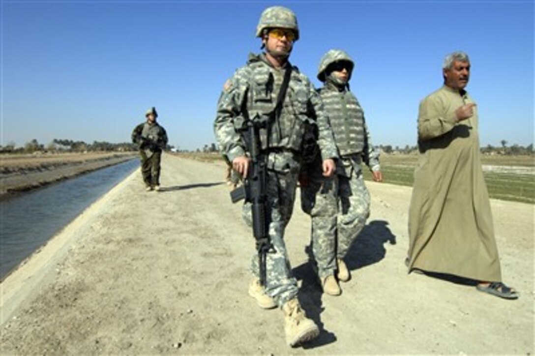 U.S. Army Maj. Ed Bowdish walks with the owner of a water pump station during a public service assessment in Al Raoud, Iraq, on Dec. 27, 2007.  Bowdish is from Alpha Company, 492nd Civil Affairs Battalion attached to the 1st Brigade Combat Team, 1st Cavalry Division.  