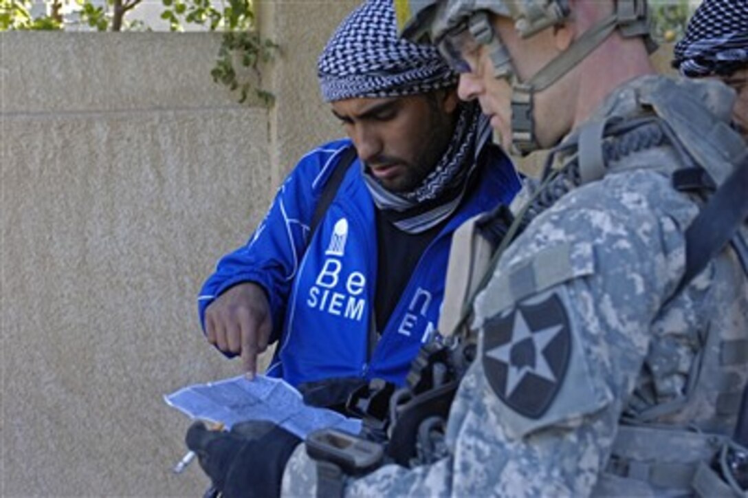 U.S. Army Sgt. Jim Korecky (right) looks over a map with an Iraqi Concerned Local Citizen in Baqubah, Iraq, on Dec. 28, 2007.  Korecky and his fellow soldiers from Charlie Company, 1st Battalion, 38th Infantry Regiment, 4th Stryker Brigade Combat Team, 2nd Infantry Division, work with the Iraqi Concerned Local Citizens to patrol their neighborhoods.  