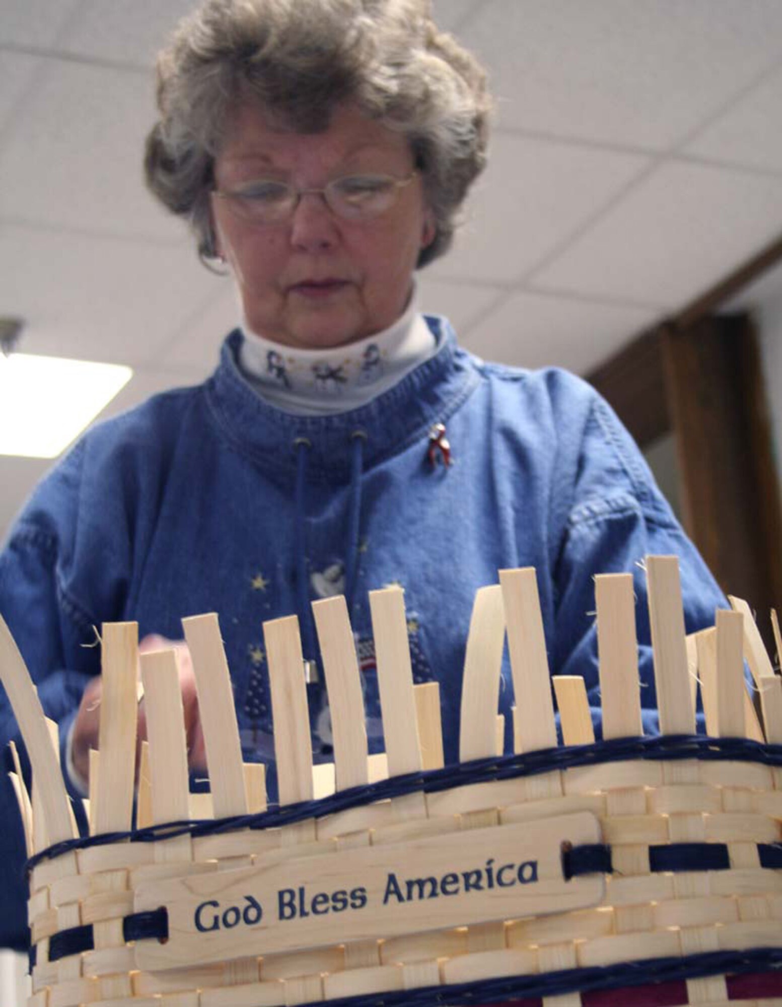 Colonel Sue Yingling, retired, intertwines reeds to create a basket at the Community Activity Center.  Ms. Yingling offers a class in basketweaving at the CAC. (U.S. Air Force Photo/Adrian McCandless)