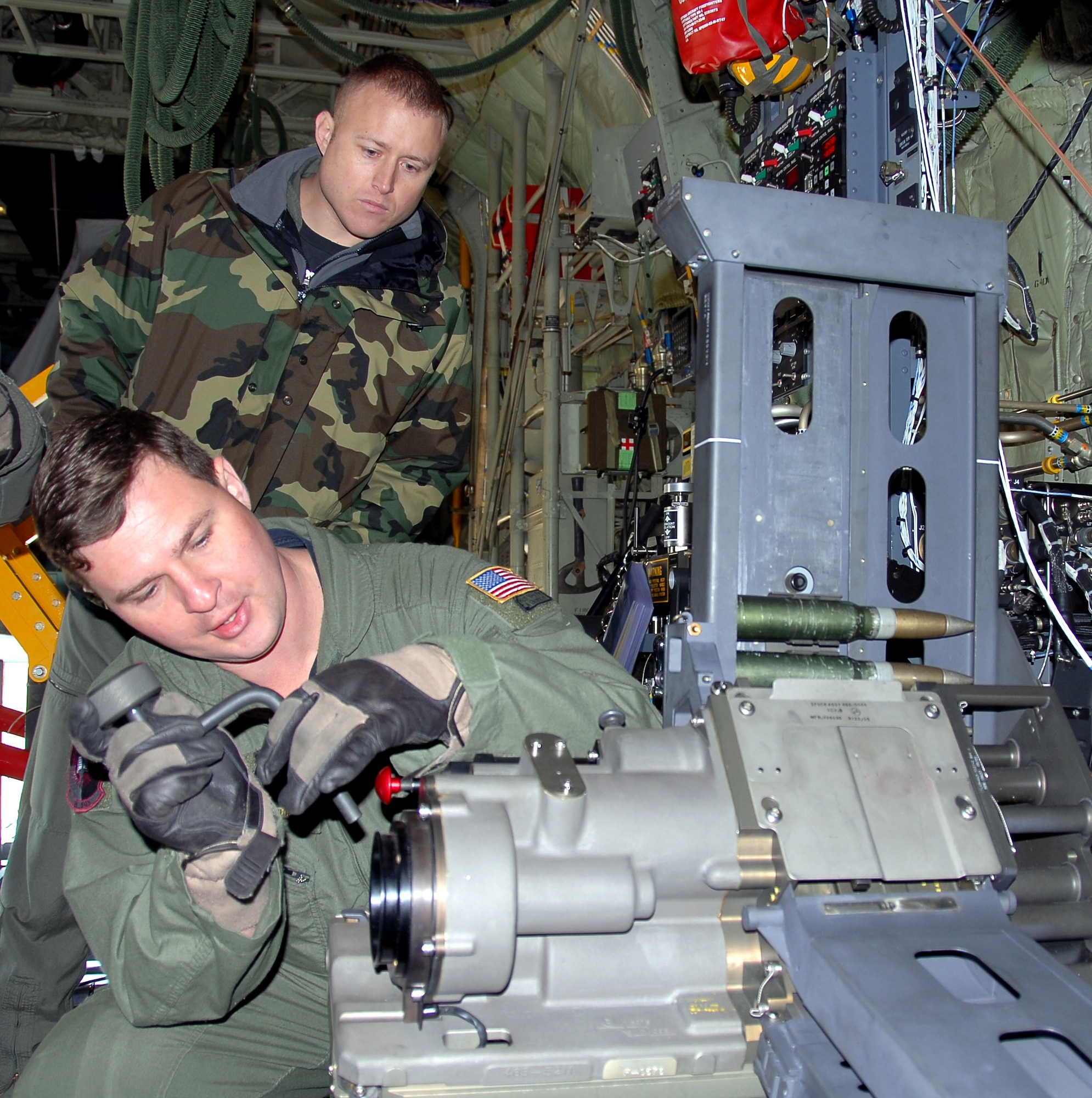 Tech. Sgt. Ben Filek works on a newly-installed 30 mm Bushmaster cannon aboard an AC-130U Spooky gunship as Tech. Sgt. James Knight looks on Jan. 26 at Hurlburt Field, Fla. Both Airmen are aerial gunners with the 19th Special Operations Squadron at Hurlburt Field. The 30 mm gun will eventually replace both the 40 mm cannon and 25 mm gun on U-model gunships. (U.S. Air Force photo/Chief Master Sgt. Gary Emery)