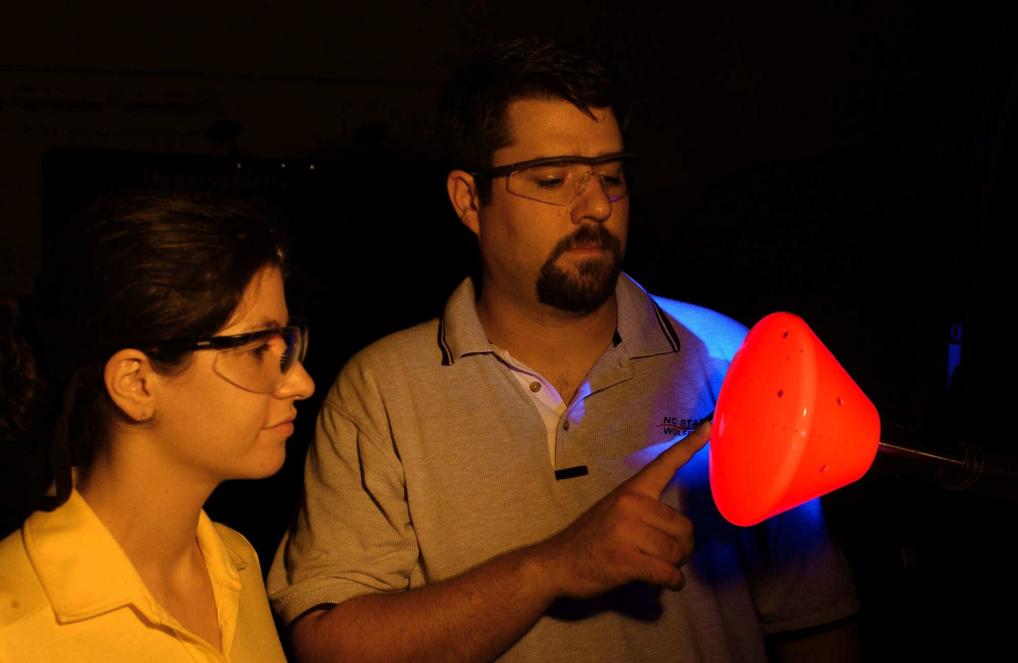 University of Maryland graduate student Inna Kurits and Tunnel 9 project engineer Joe Norris examine the illuminated Temperature Sensitive Paint coating on the NASA crew exploration vehicle model prior to a run. (Air Force photo by Arnold Collier)