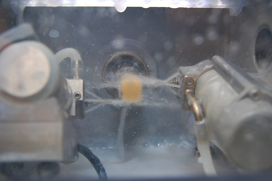 The Moody dental clinic's new precision milling machine uses two fine diamond coated burrs to grind away at a ceramic block to create crowns ,bridges, or veneers. The $64,000 computerized milling system shortens the processing time of the dental work from six weeks to a couple of hours. (U.S. Air Force photo By Tech. Sgt. Parker Gyokeres)
