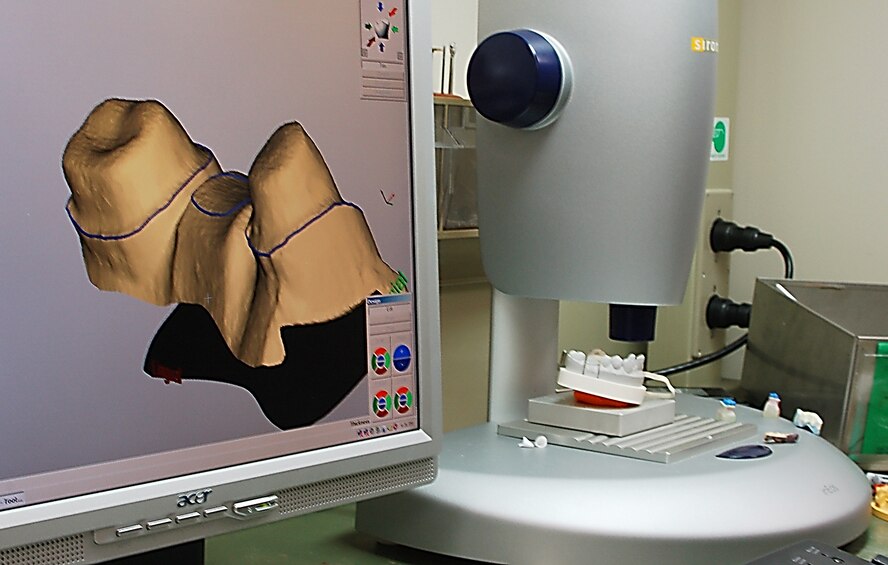 Using new dental technology, a camera scans a casting or mold and sends an extremely high resolution three-dimensional image to the modeling computer.  The item needed is then created in a virtual environment and either transmitted to the Area Dental Lab, or created in-house on a precision milling machine. The $64,000 computerized milling system shortens the processing time to create crowns and bridges from six weeks to a couple of hours. (U.S. Air Force photo by Tech. Sgt. Parker Gyokeres)

